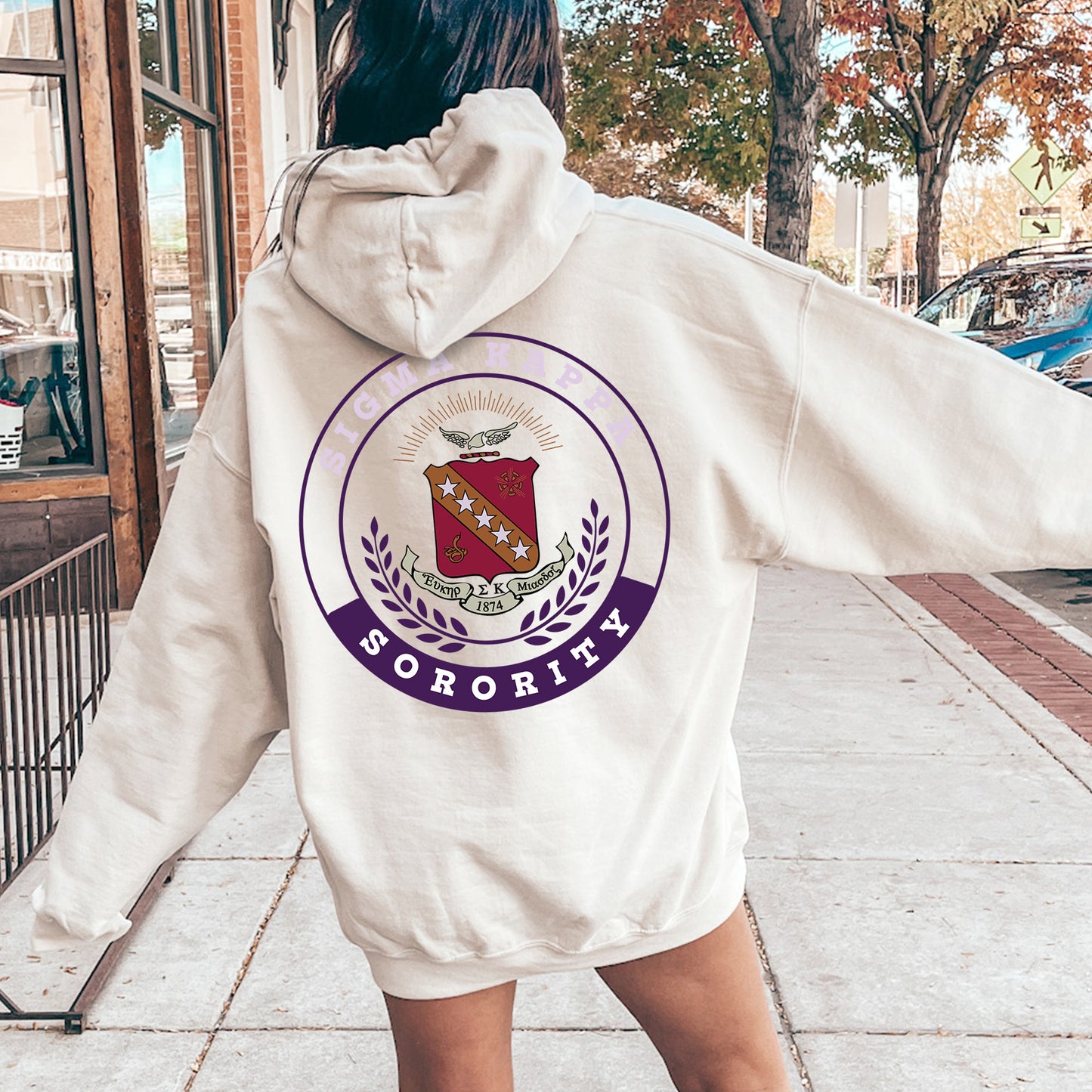 a woman in a white hoodie is walking down the street