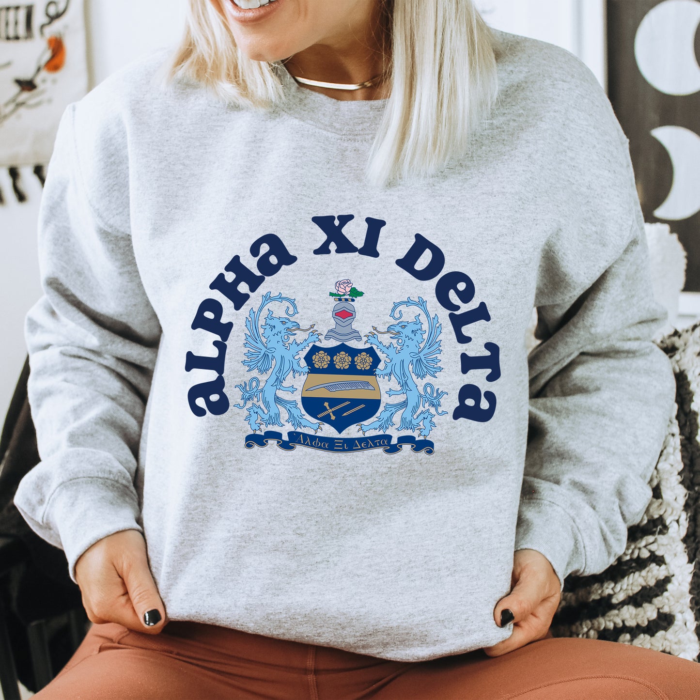 a woman sitting on a chair wearing a grey sweatshirt