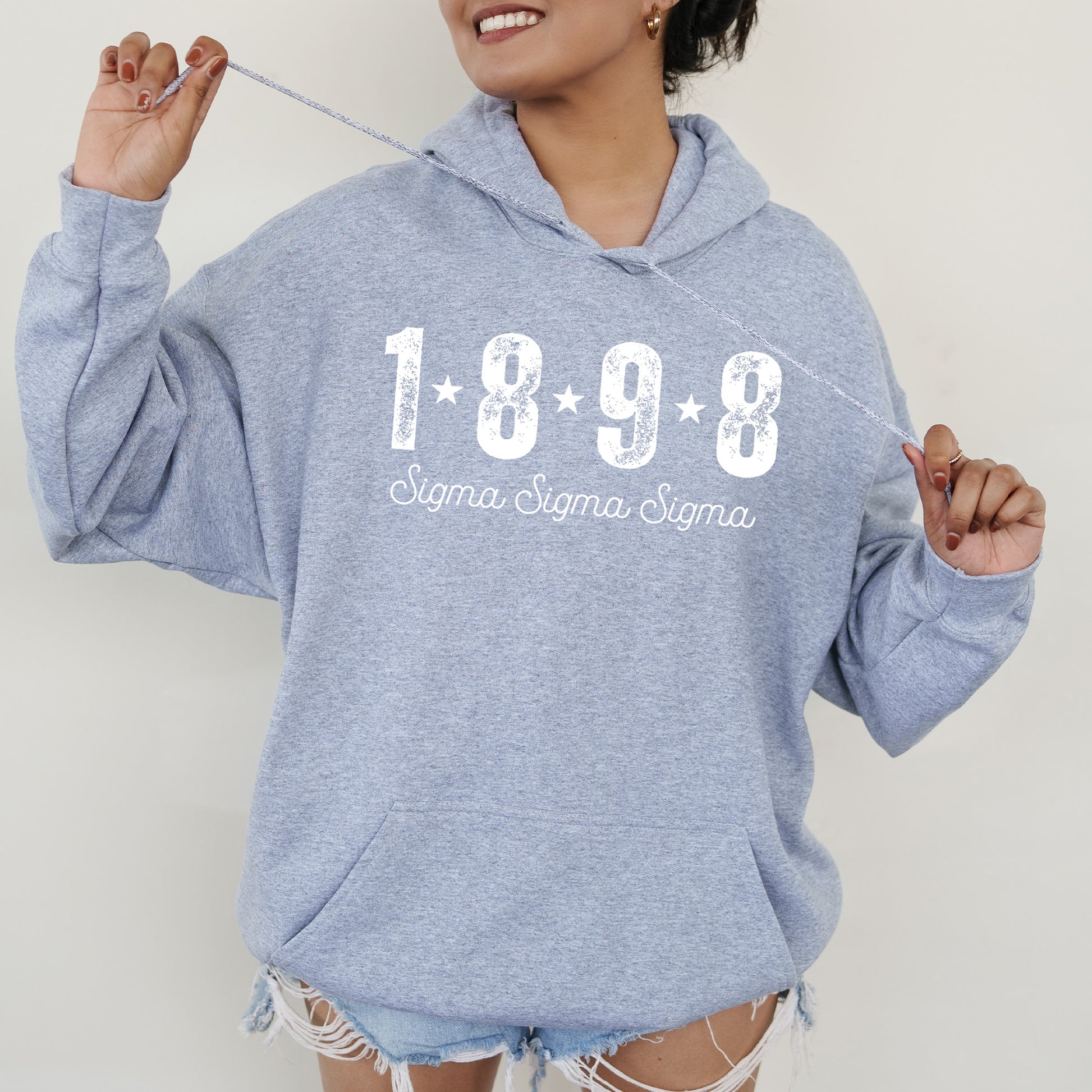 a woman in a blue hoodie is holding a toothbrush