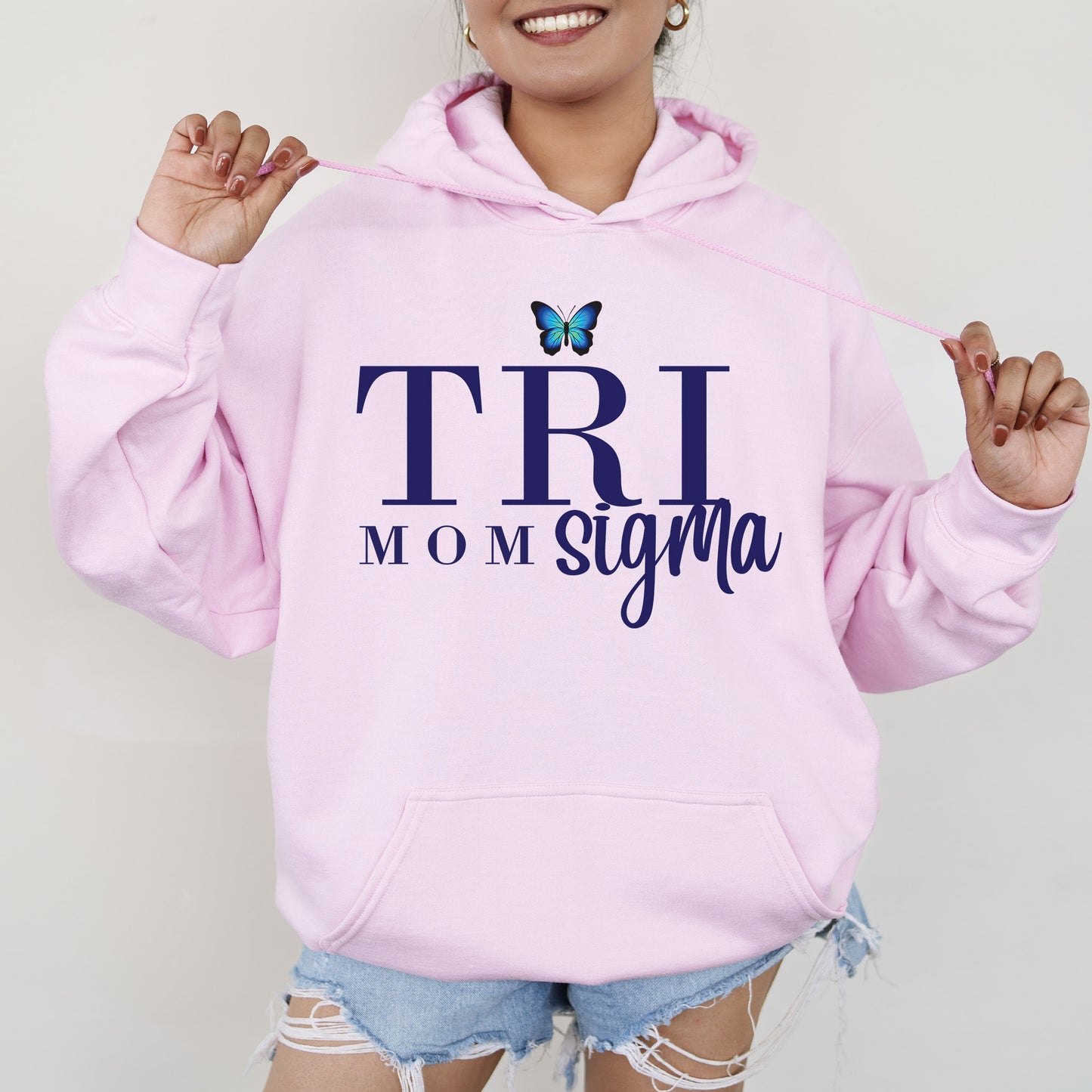 a woman wearing a pink hoodie with a butterfly on it