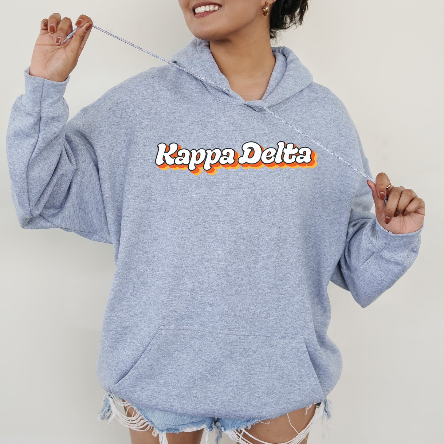 a woman in a blue hoodie holding a toothbrush