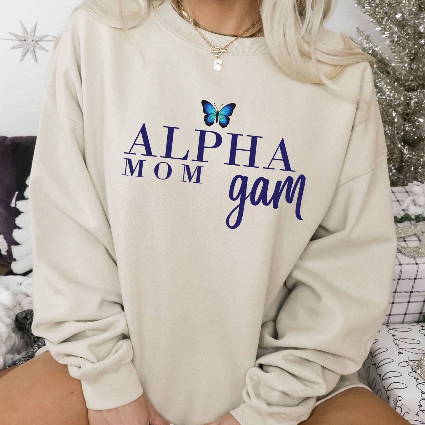 a woman sitting on a bed wearing a sweatshirt