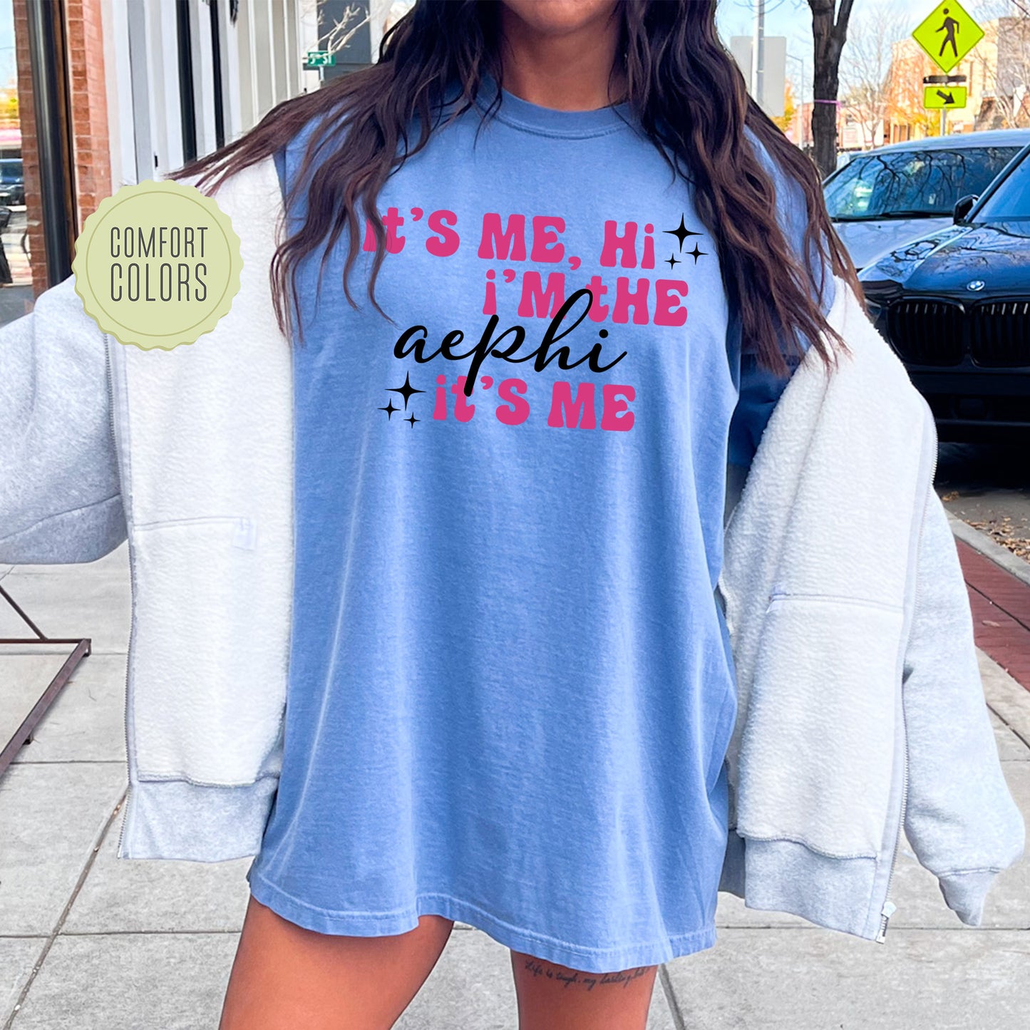 a woman standing on a sidewalk wearing a shirt that says it's me,