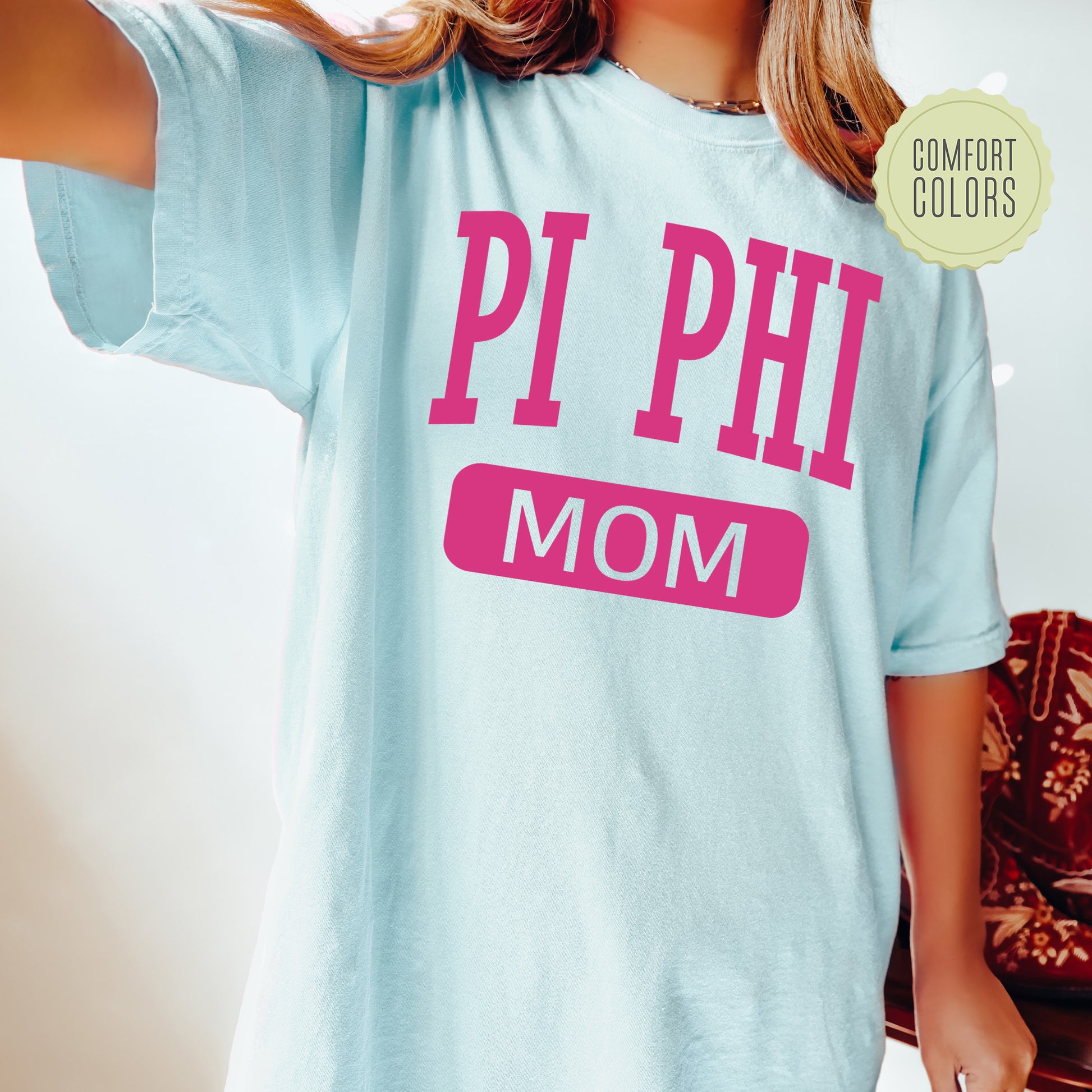 a woman wearing a pi phi mom shirt