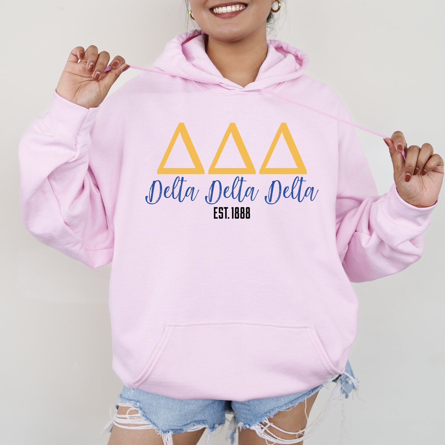 a woman wearing a pink delta delta hoodie