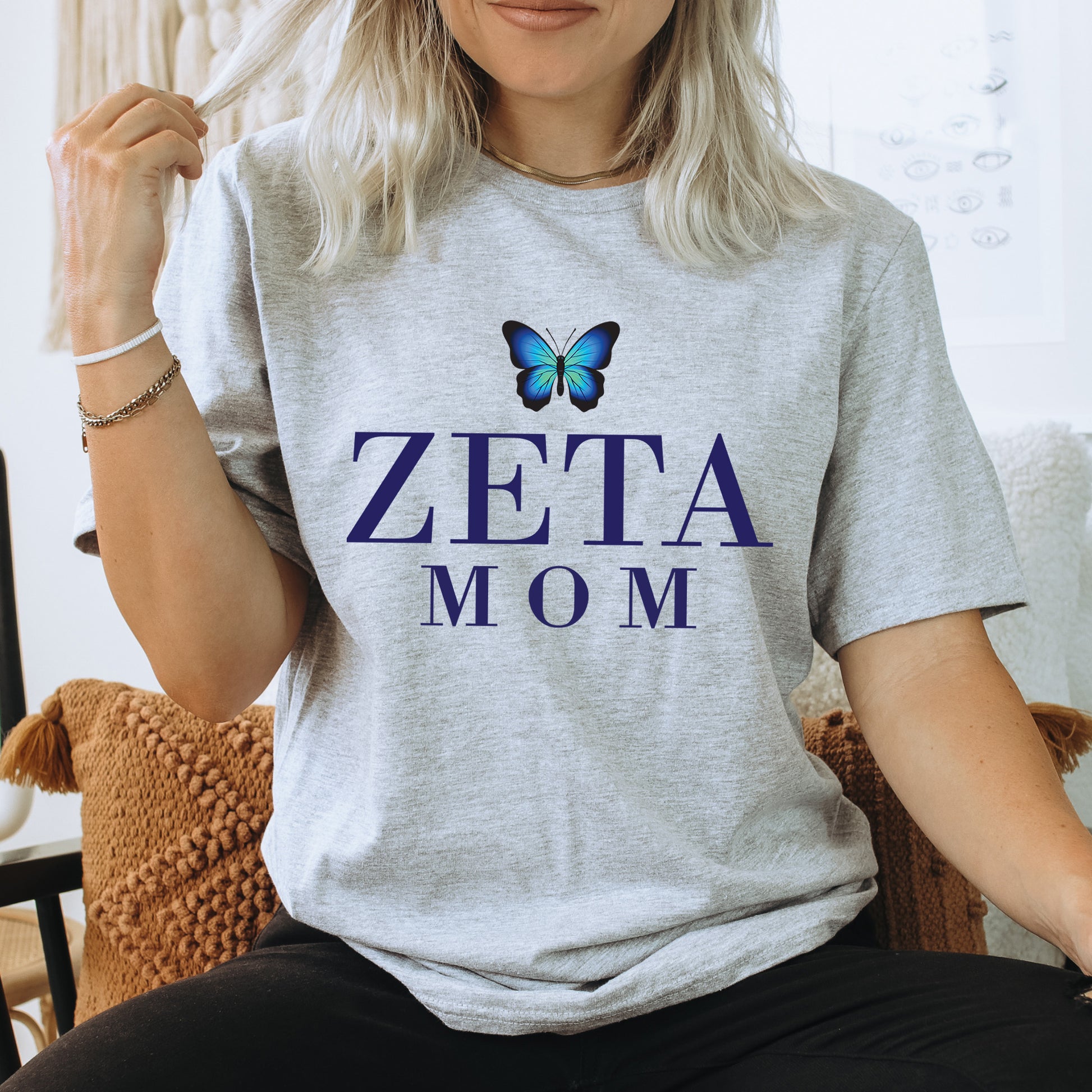 a woman sitting on a chair with a butterfly on her shirt