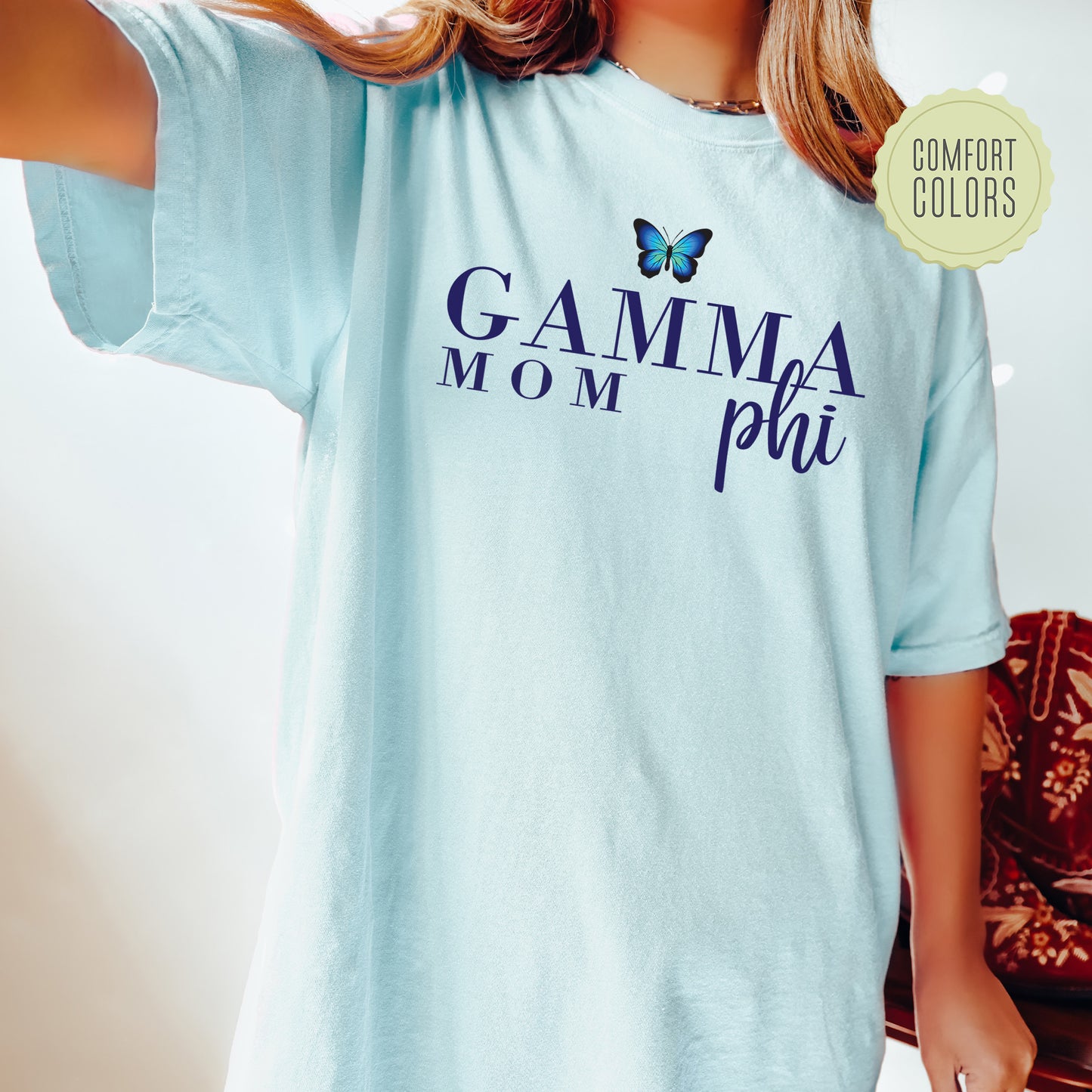 a woman wearing a light blue shirt with a butterfly on it
