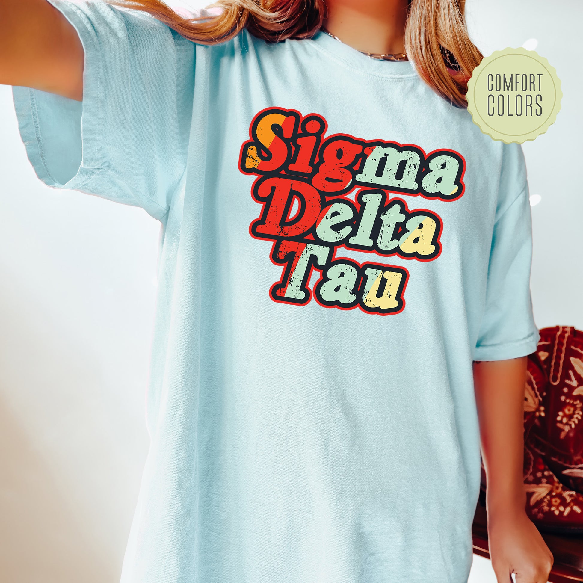 a woman wearing a blue shirt that says sigmma delta tau