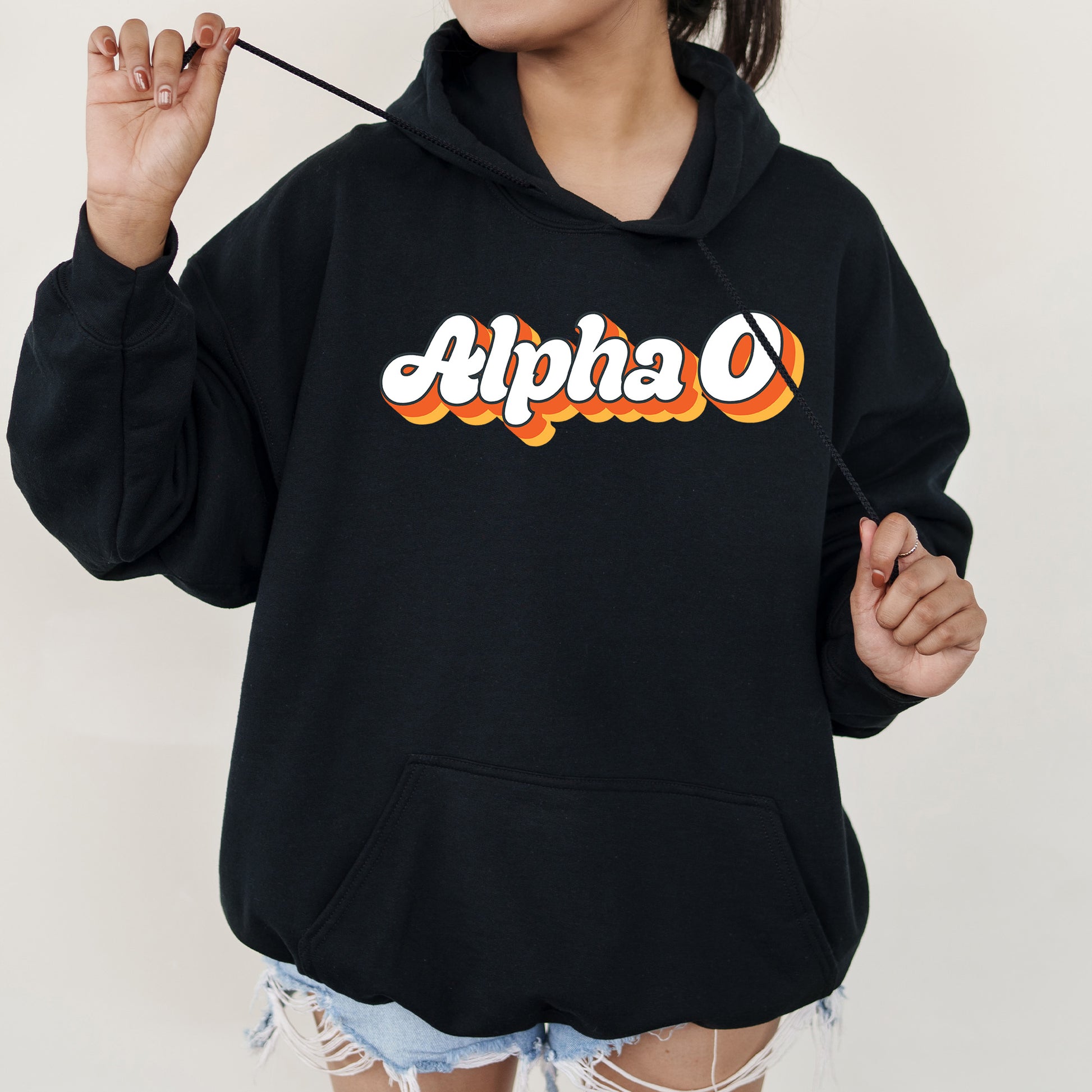 a woman wearing a black hoodie with the word alpha on it