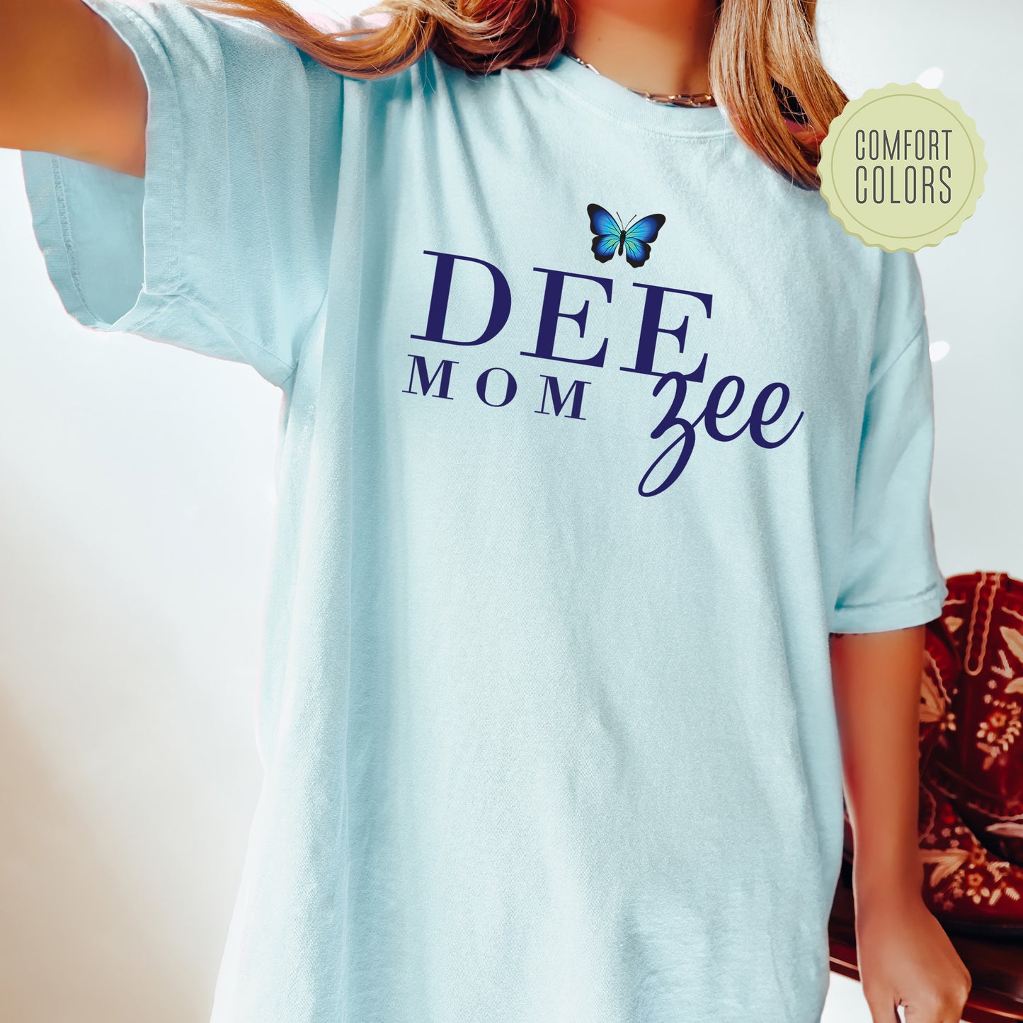 a woman wearing a blue shirt with a butterfly on it