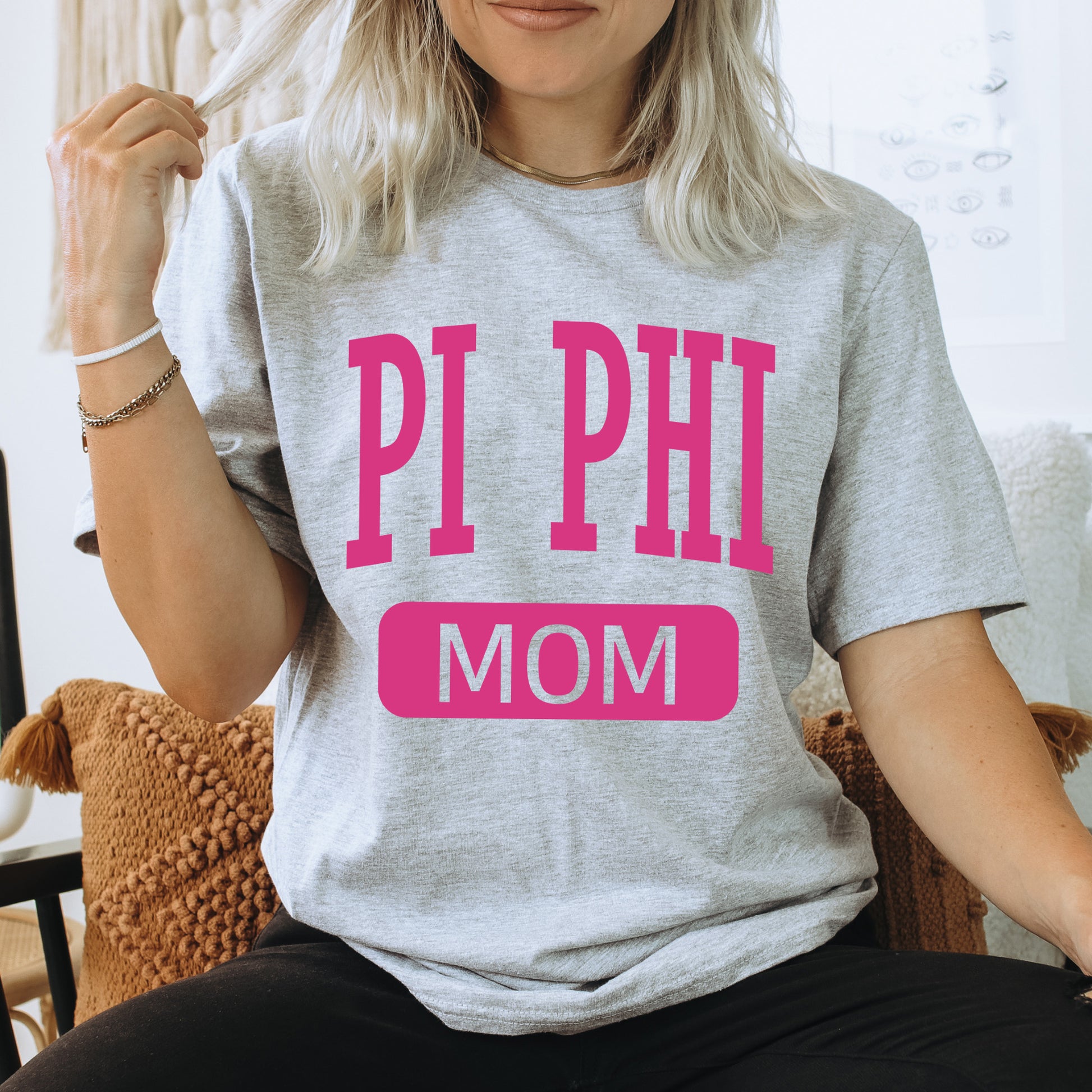 a woman wearing a pi phi mom t - shirt
