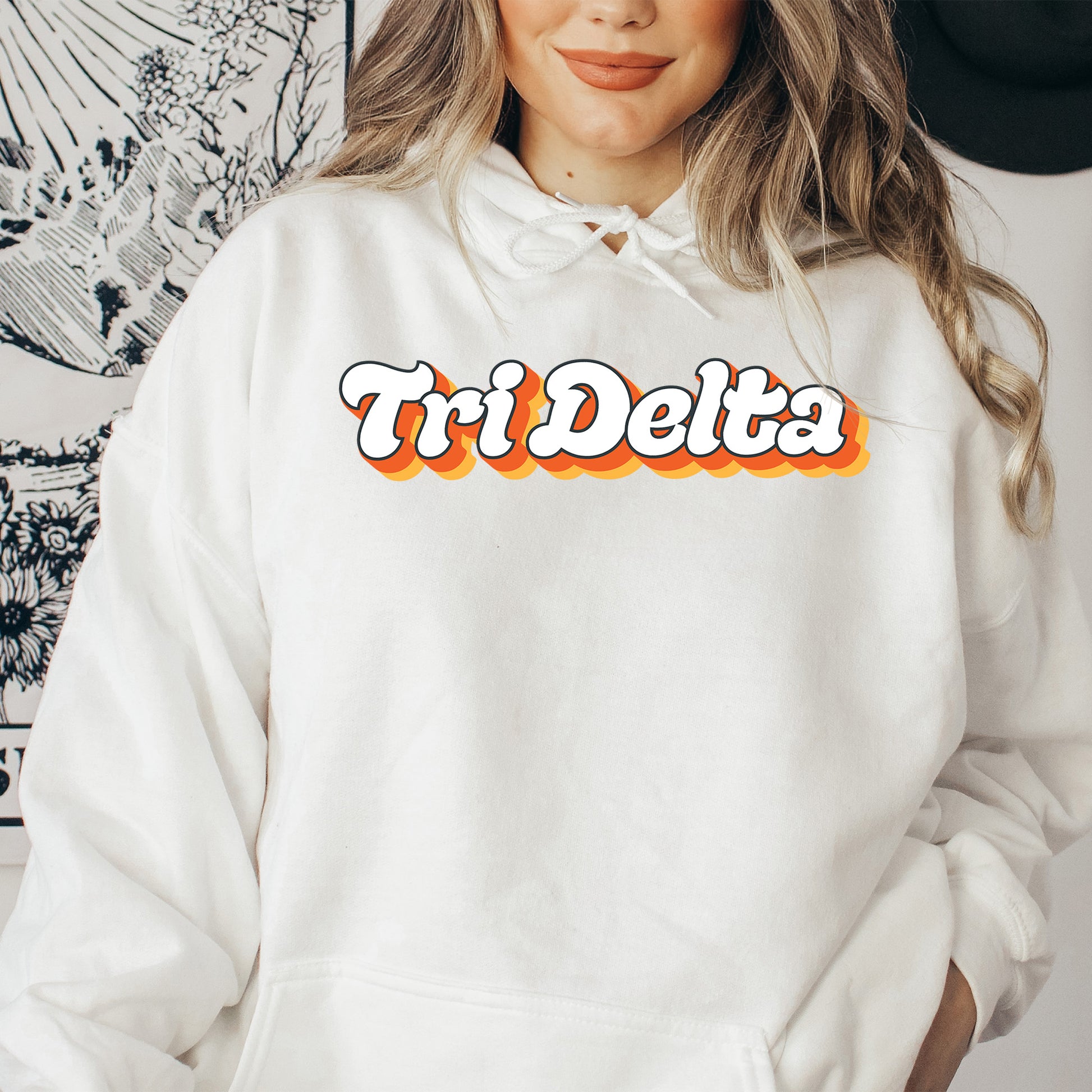 a woman wearing a white hoodie with the word tri delta printed on it