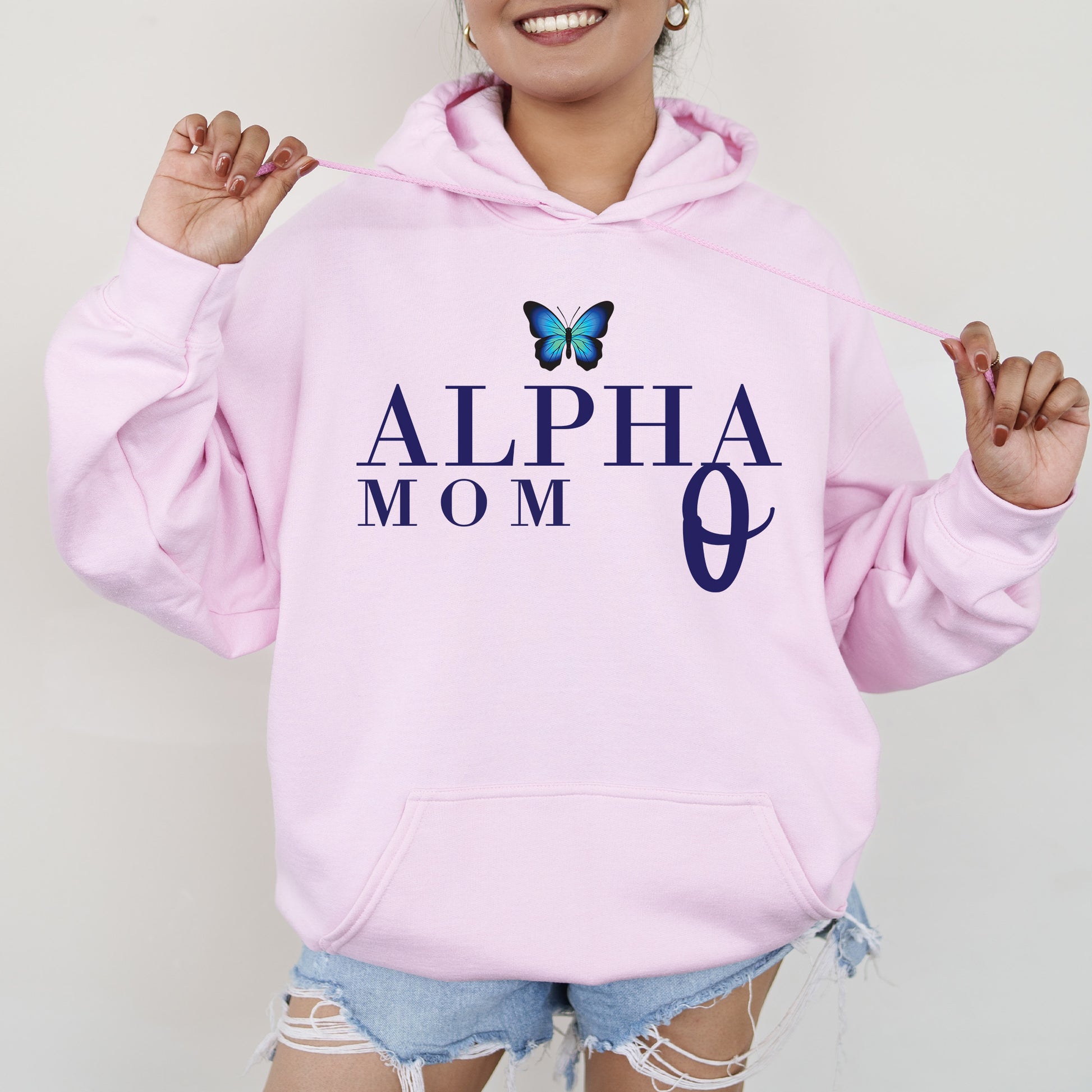 a woman wearing a pink hoodie with a butterfly on it
