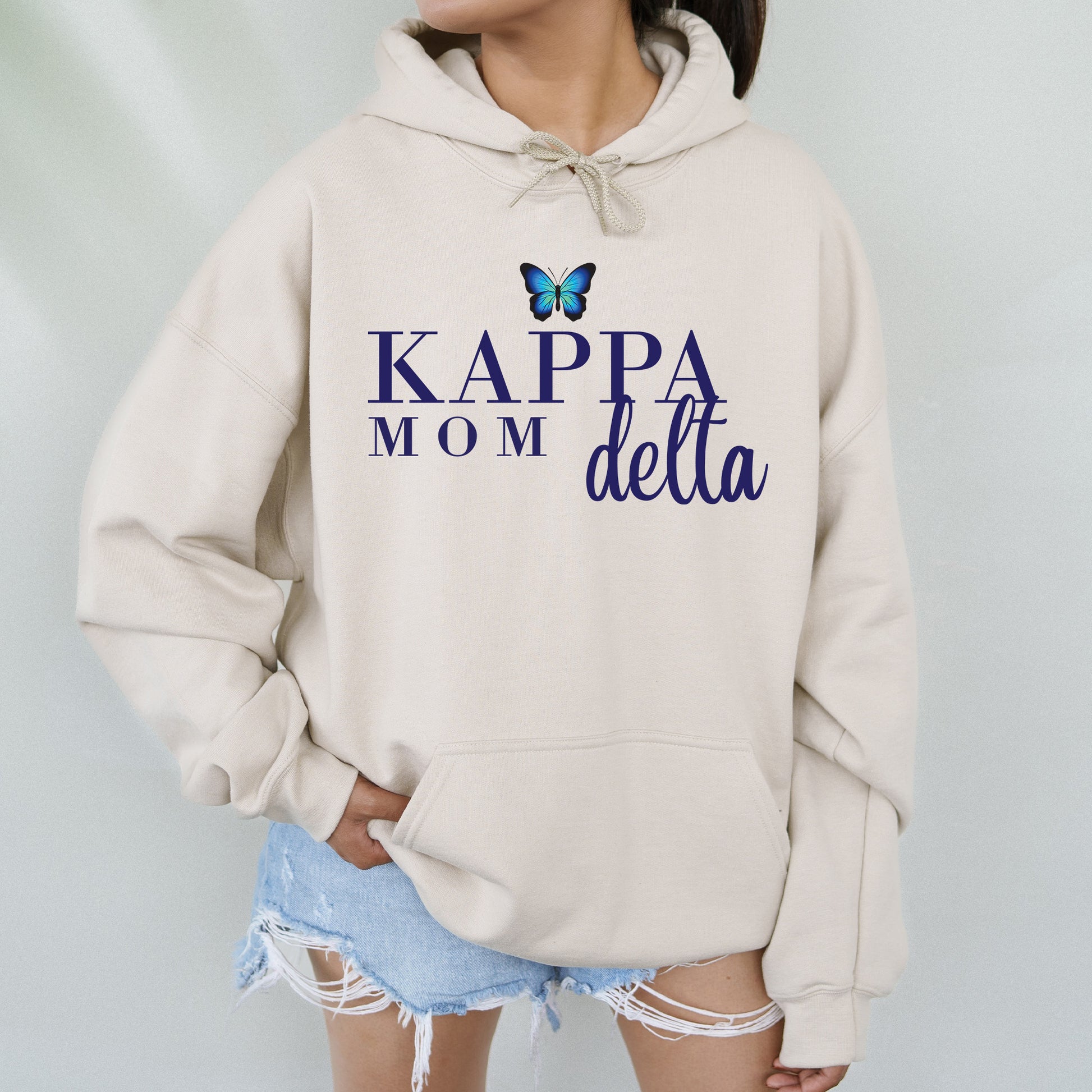 a woman wearing a sweatshirt that says kapa mom delta