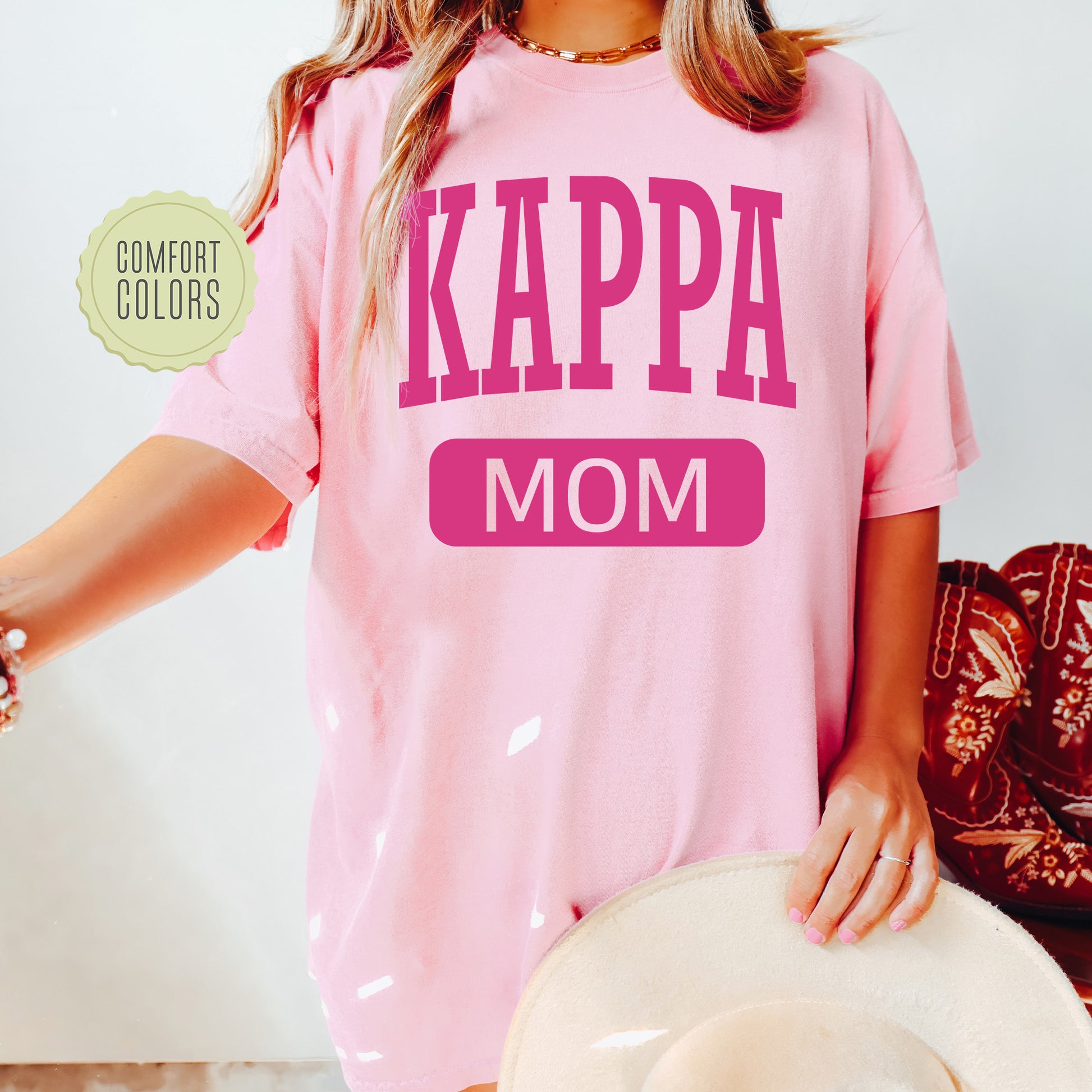 a woman wearing a pink shirt that says kappa mom