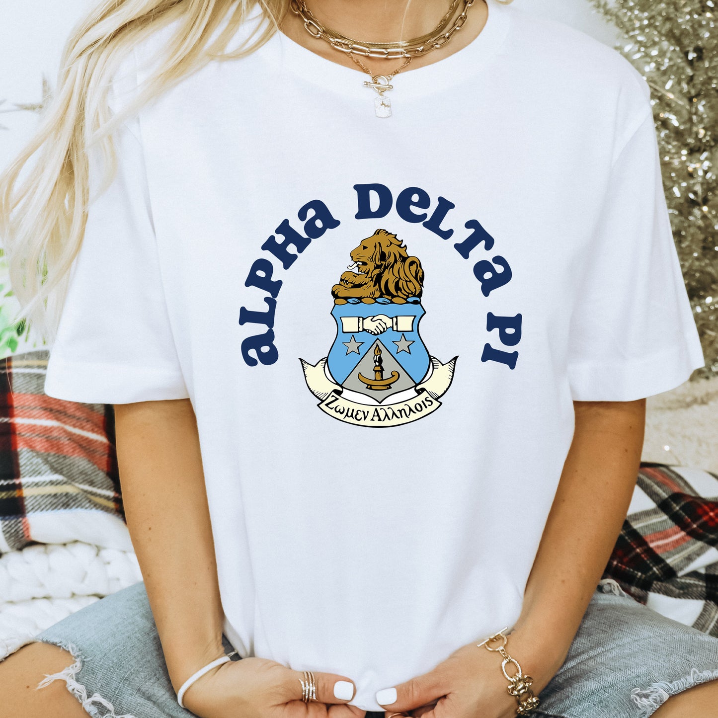 a woman wearing a white shirt with a coat of arms on it