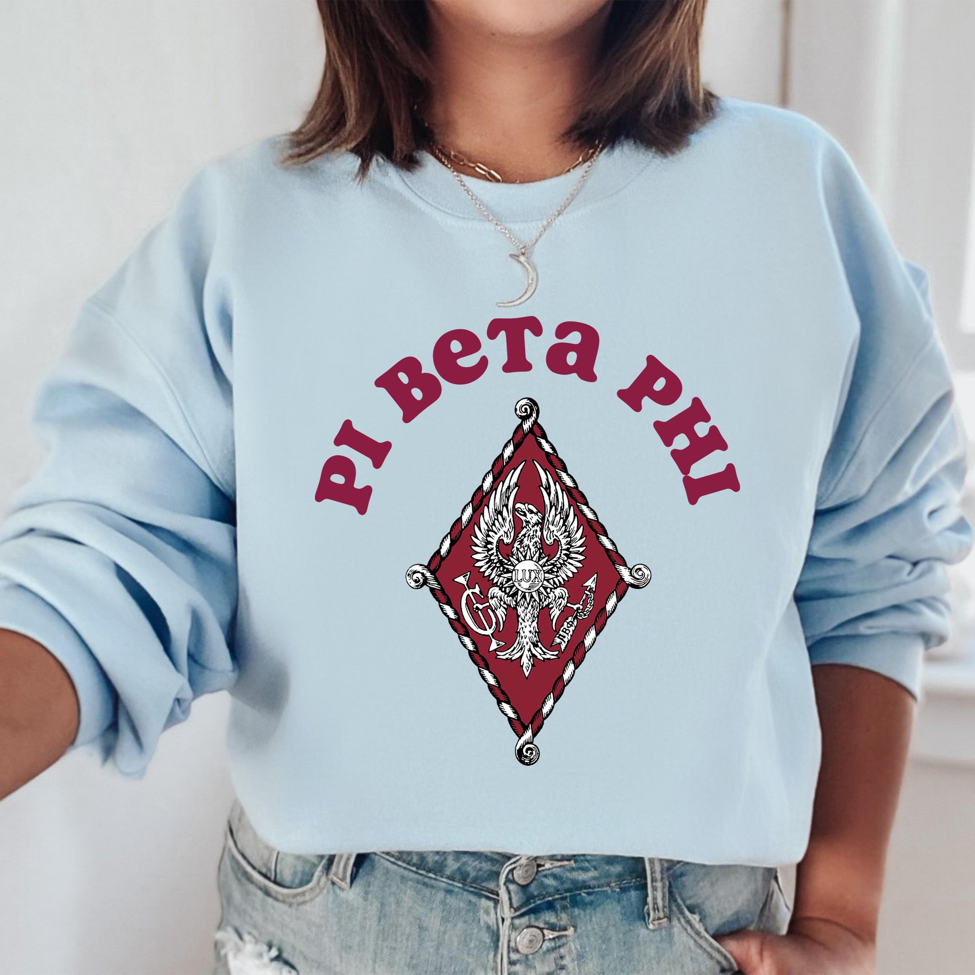 a woman wearing a blue sweatshirt with a red and white design on it