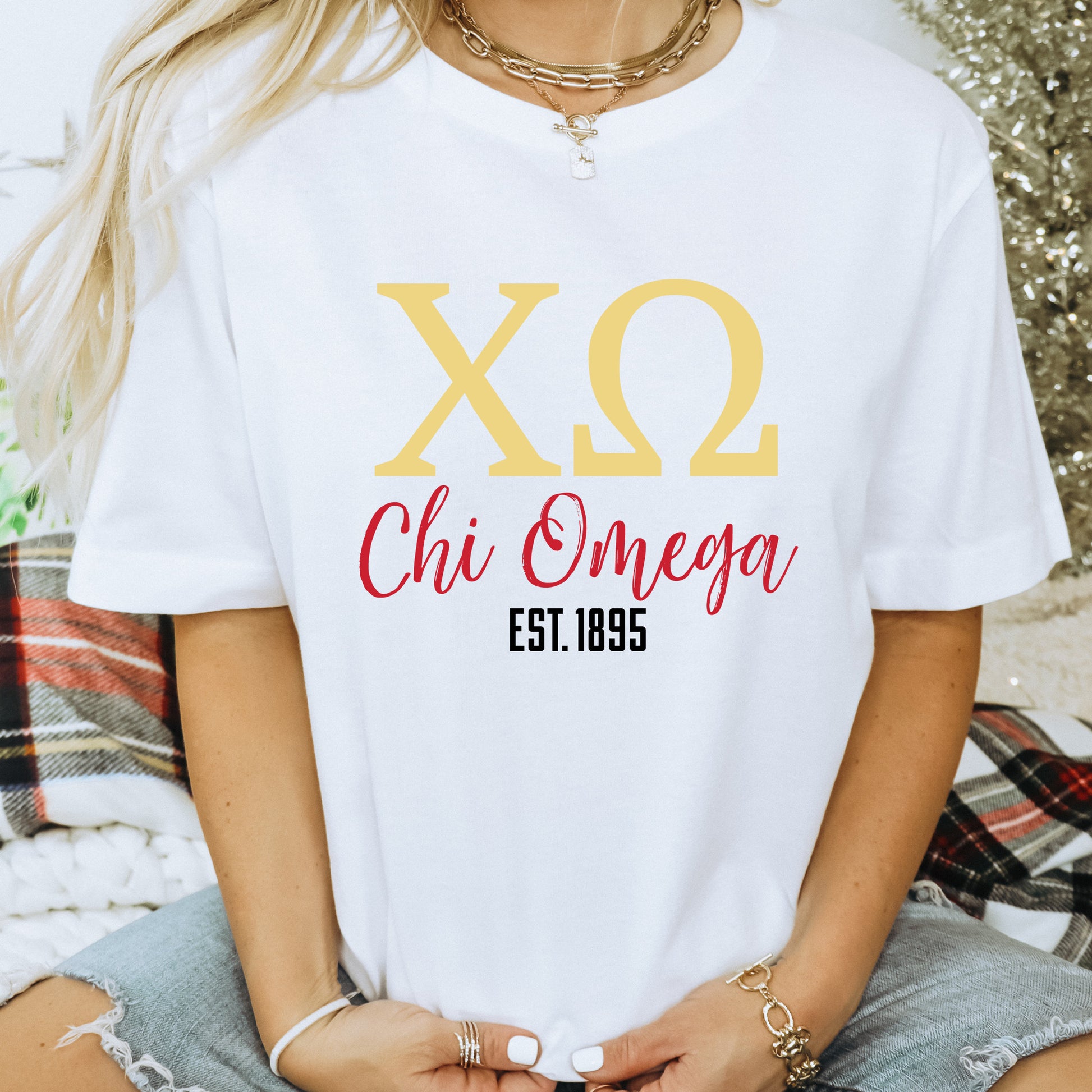 a woman wearing a white shirt that says xo chi omega