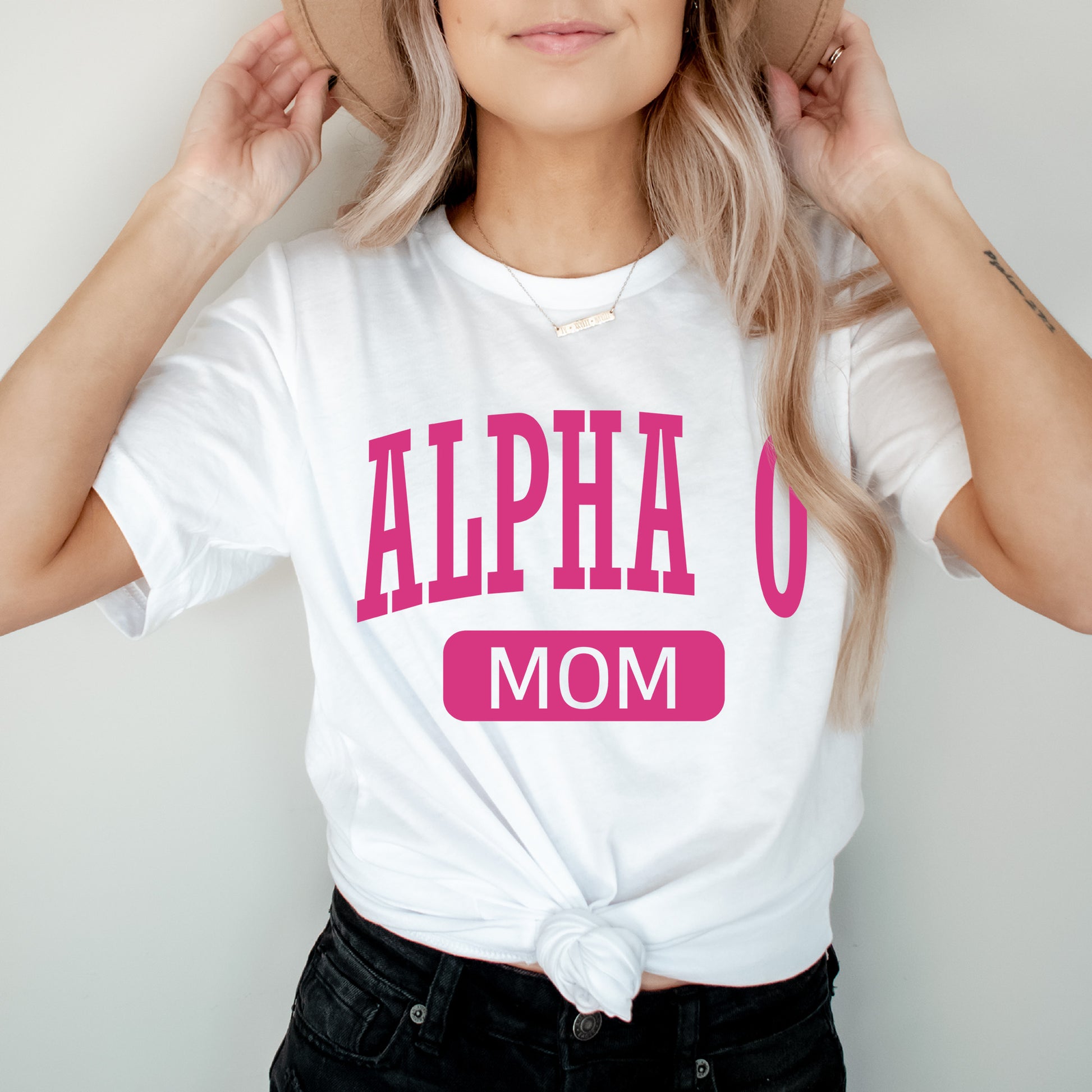 a woman wearing a white shirt with pink letters on it