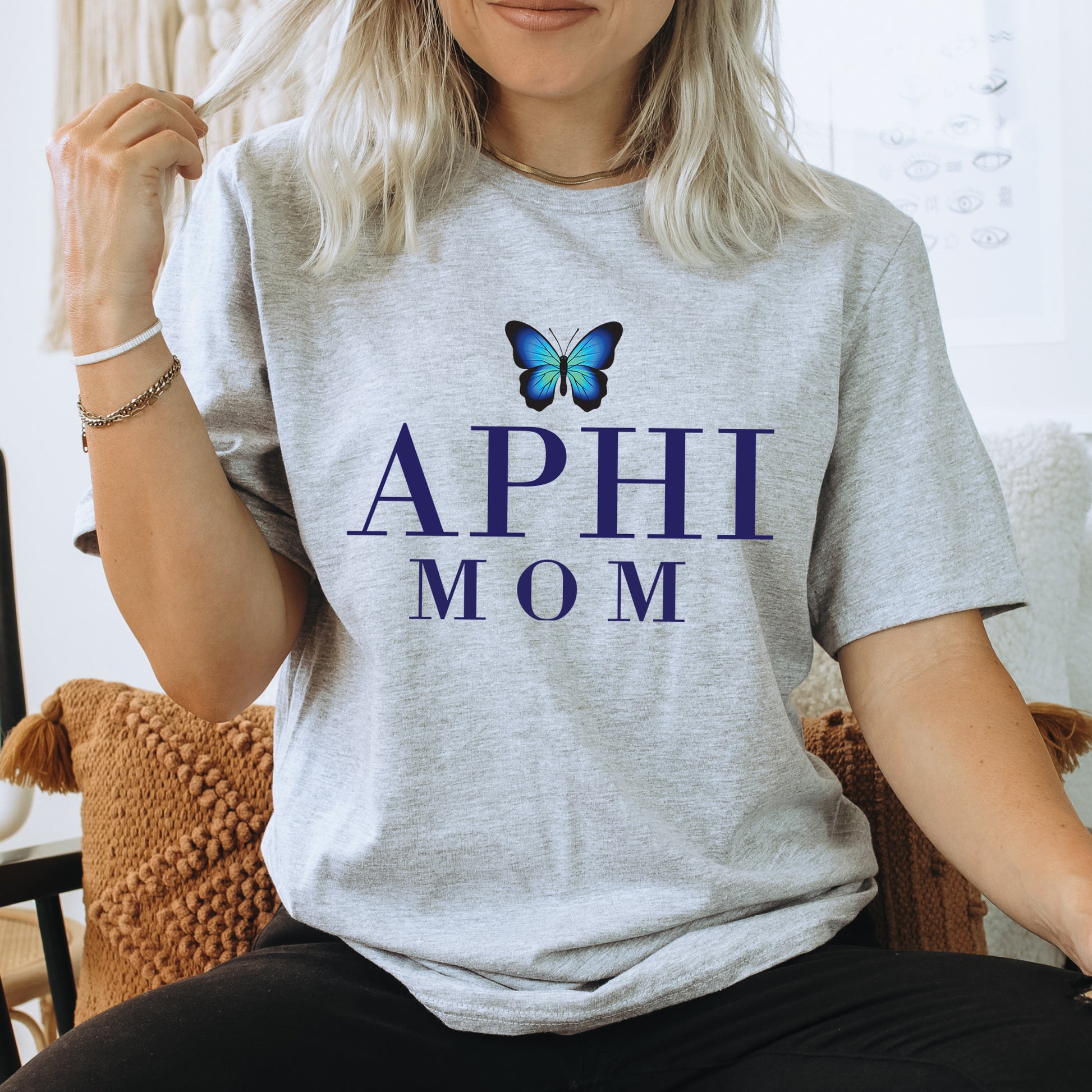 a woman sitting on a chair with a butterfly on her shirt