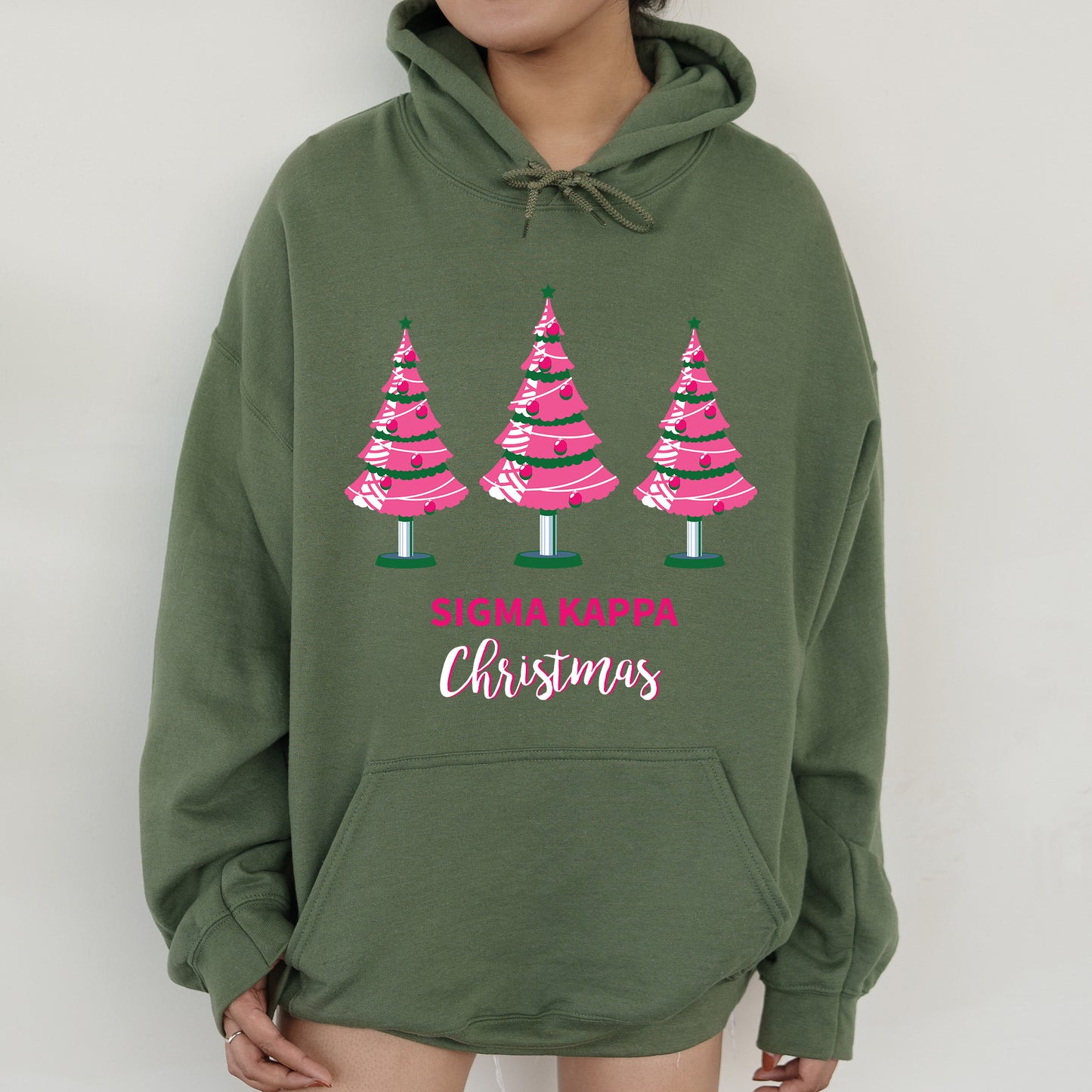 a woman wearing a green sweatshirt with pink trees on it