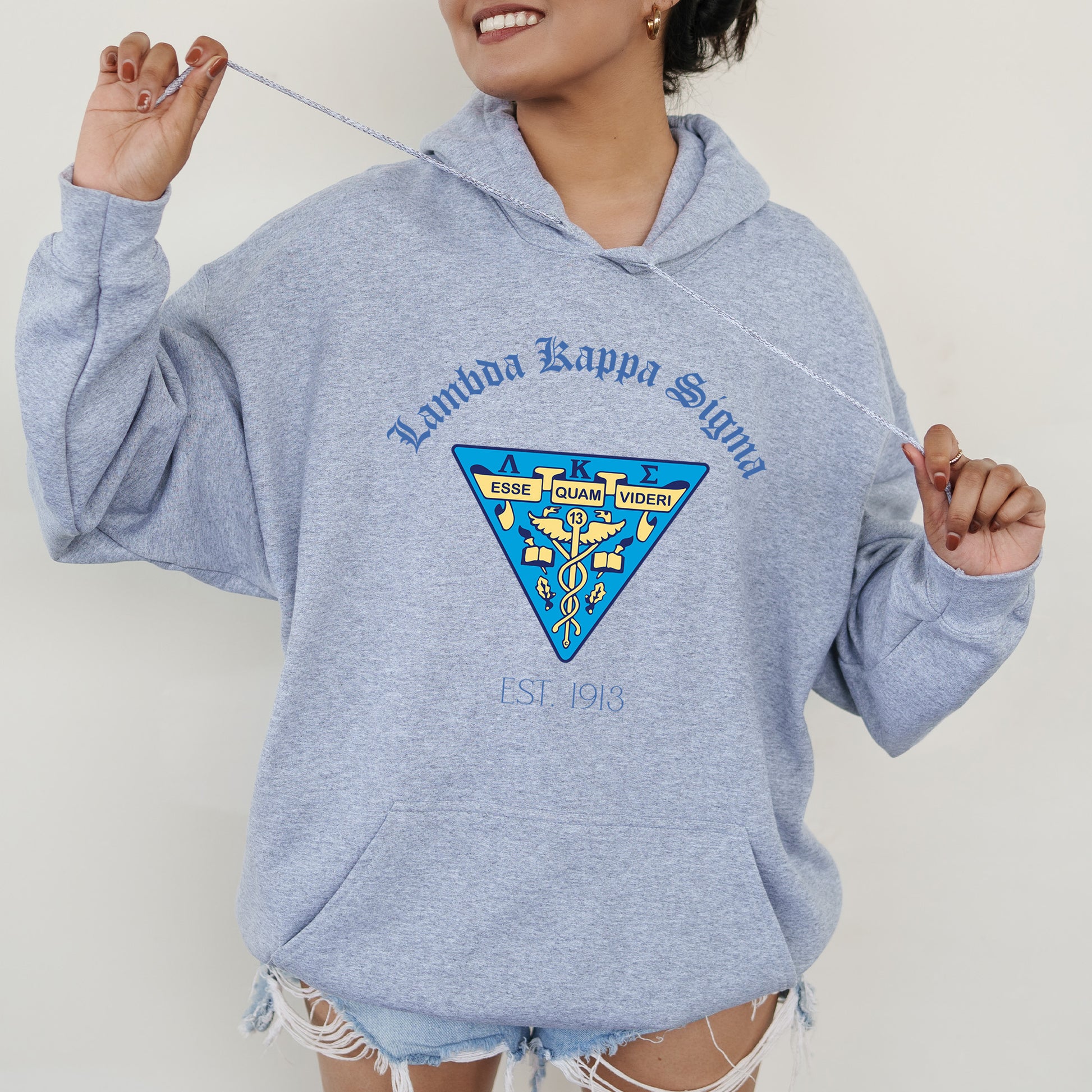 a woman in a blue hoodie holding a toothbrush