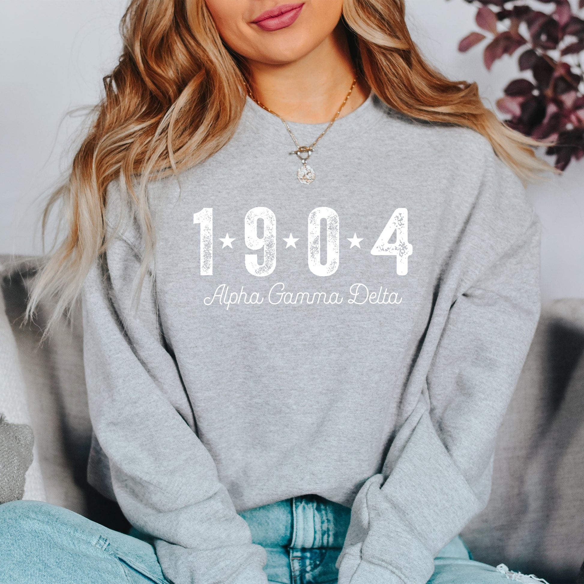 a woman sitting on a couch wearing a sweatshirt