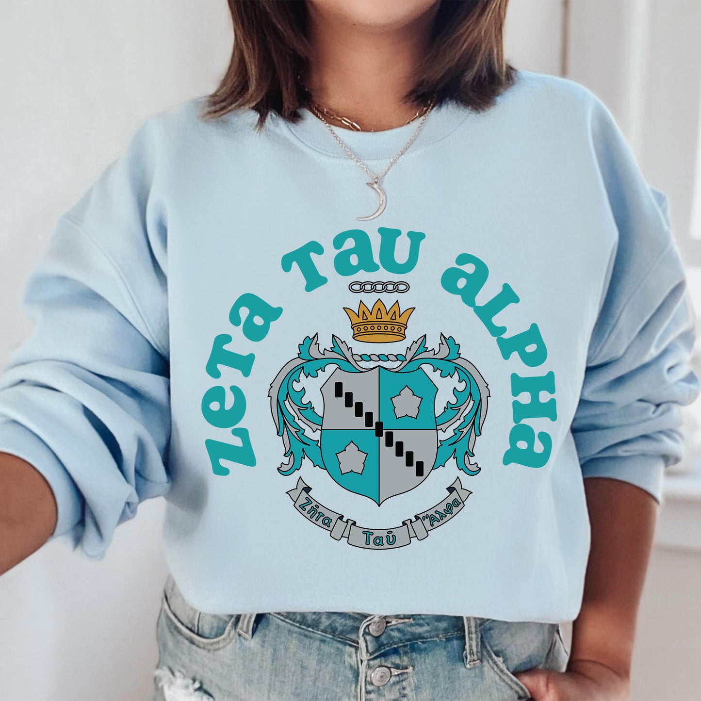 a woman wearing a blue sweatshirt with a crown on it