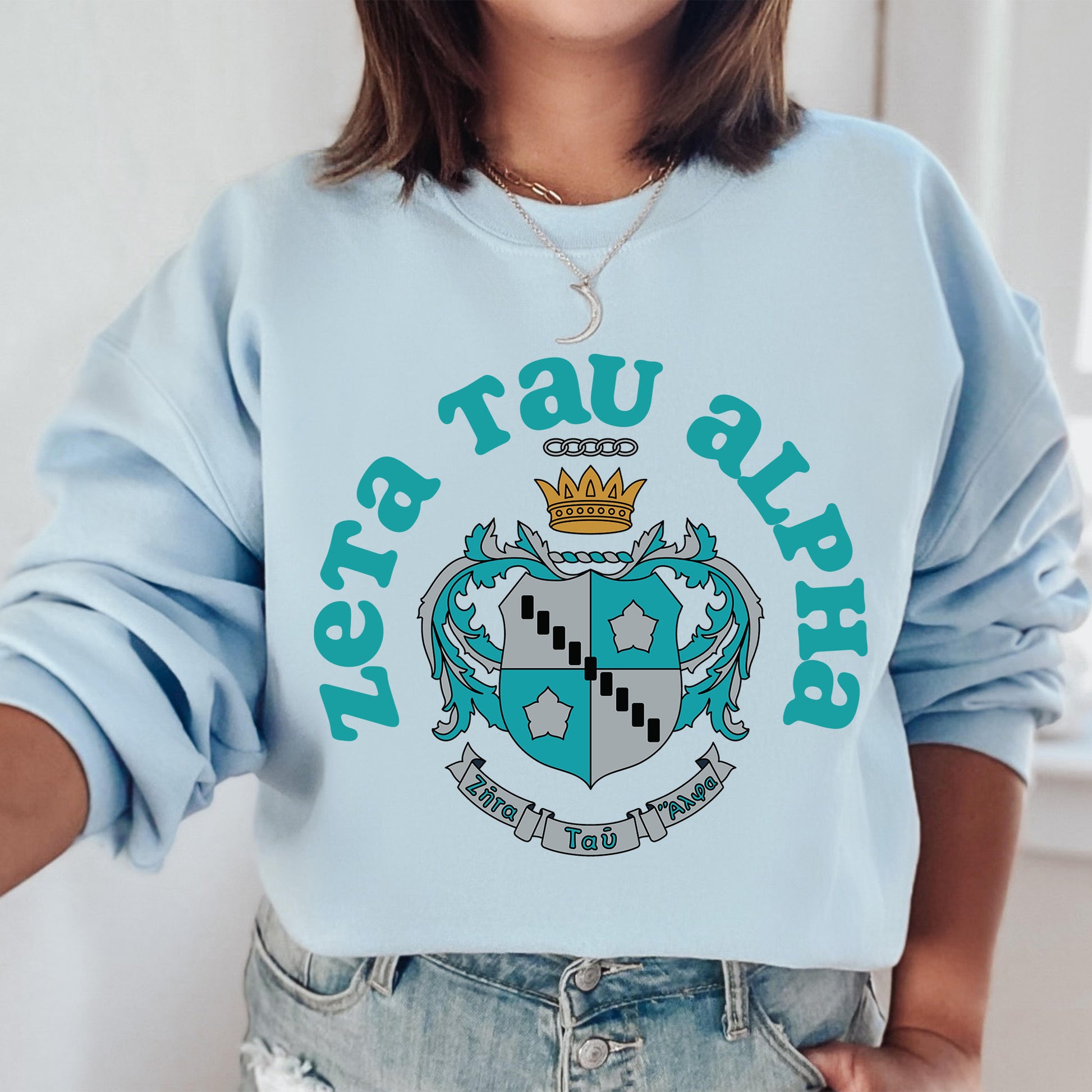 a woman wearing a blue sweatshirt with a crown on it