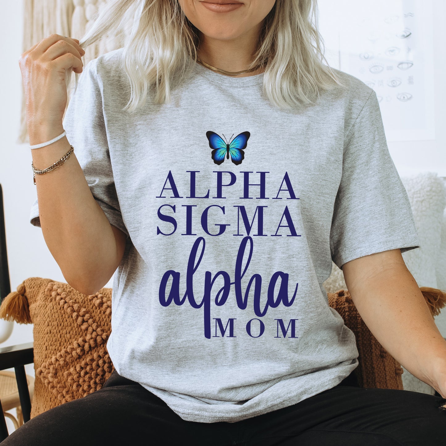 a woman sitting on a chair with a butterfly on her shirt