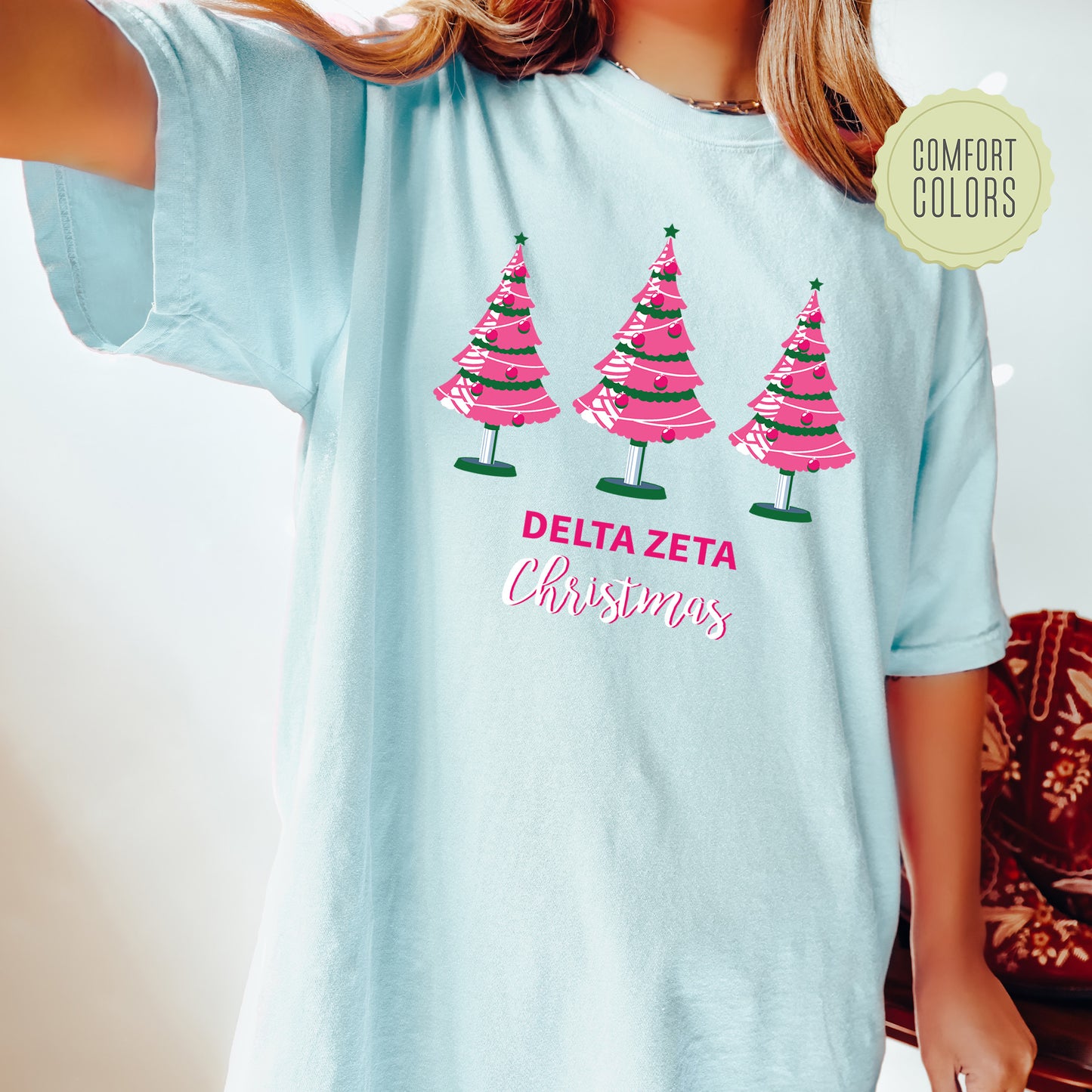 a girl wearing a blue shirt with pink trees on it