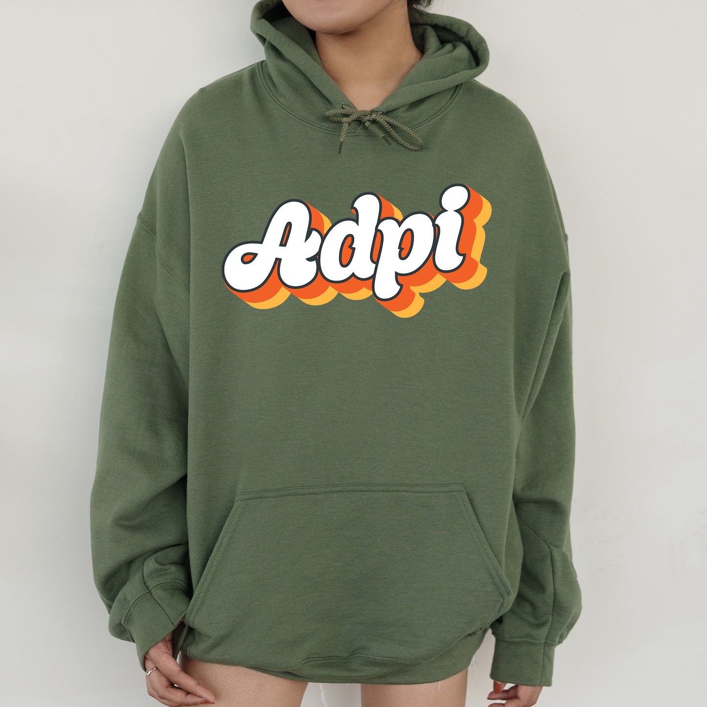 a person wearing a green hoodie with the word adpi printed on it