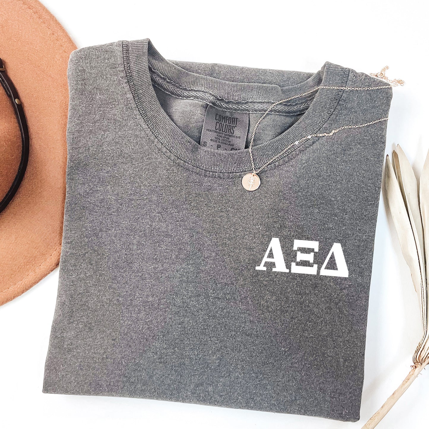 a hat, sunglasses, and t - shirt on a white surface