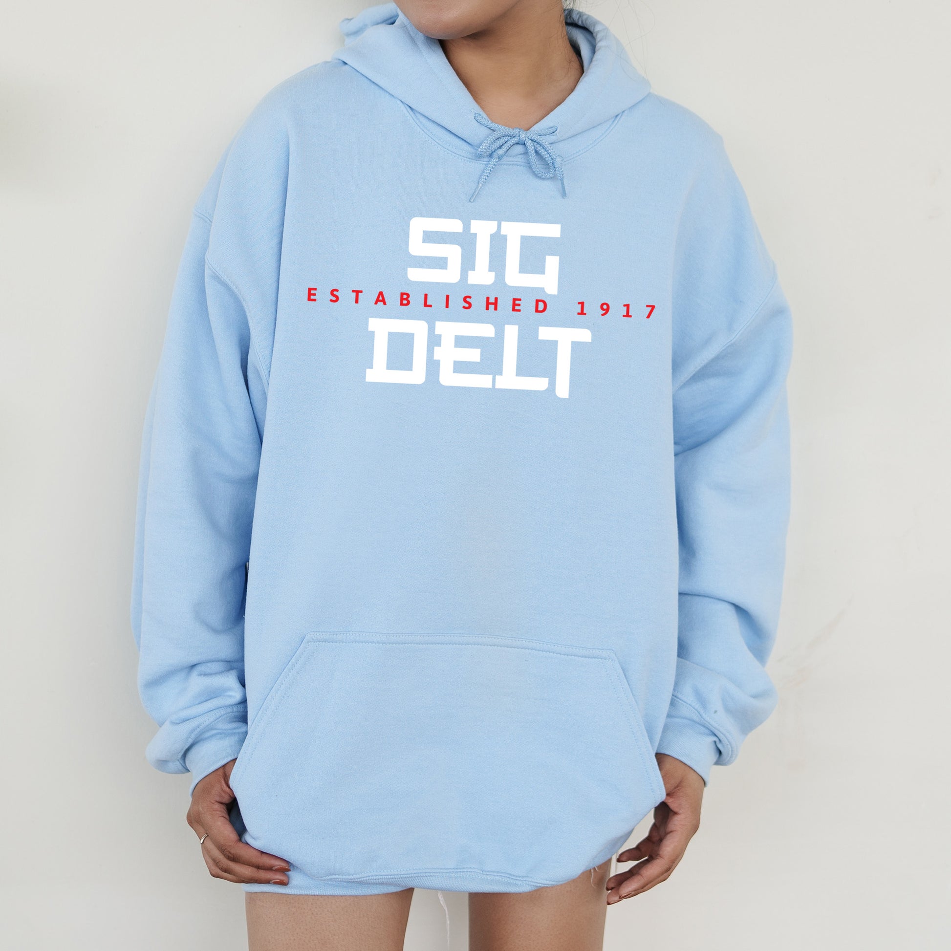 a person wearing a blue hoodie that says sig established 2011