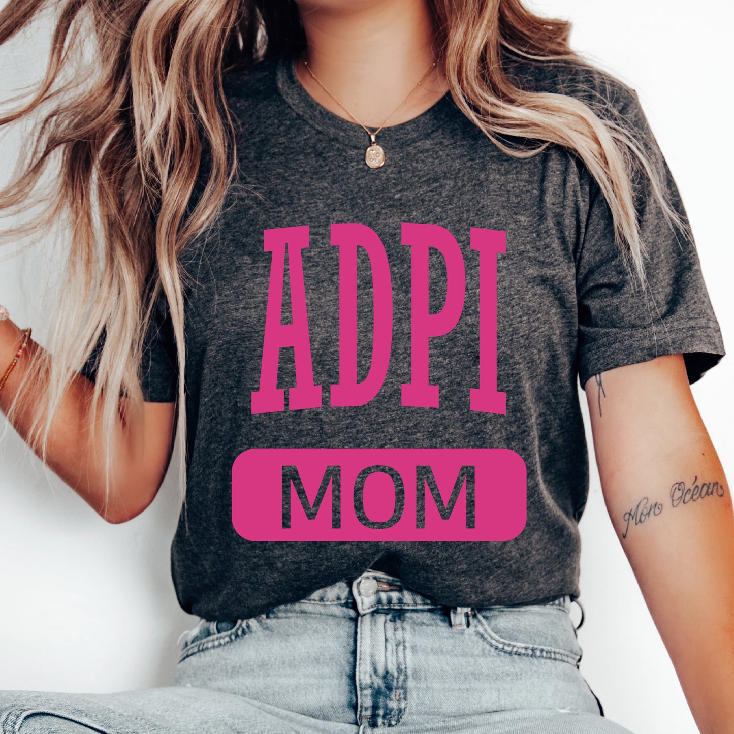 a woman wearing a t - shirt with the words adpi mom on it