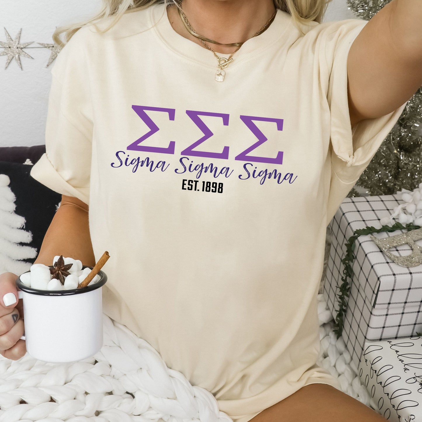 a woman sitting on a bed holding a cup of coffee