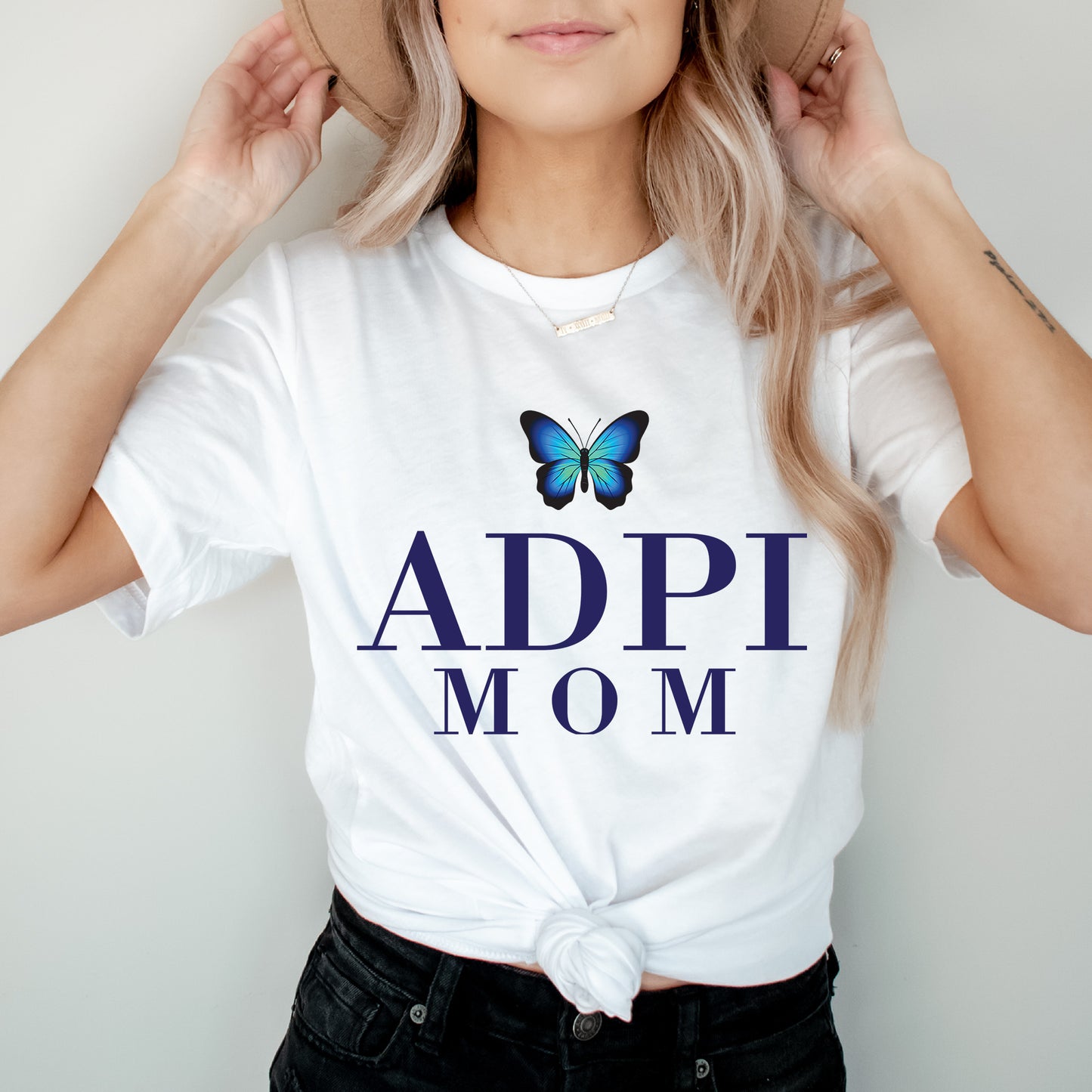 a woman wearing a hat and a t - shirt with a butterfly on it