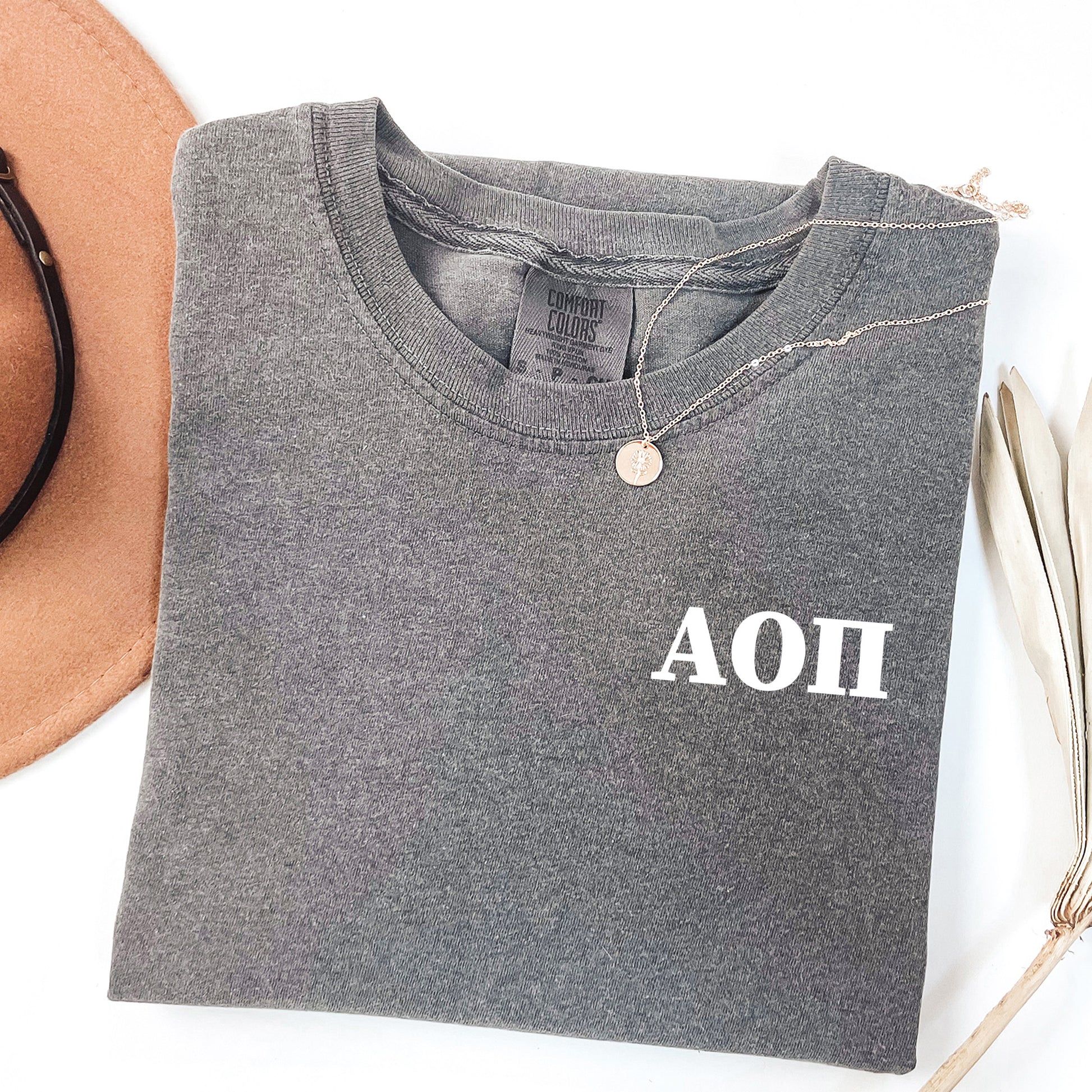 a hat, sunglasses, and a t - shirt on a white surface