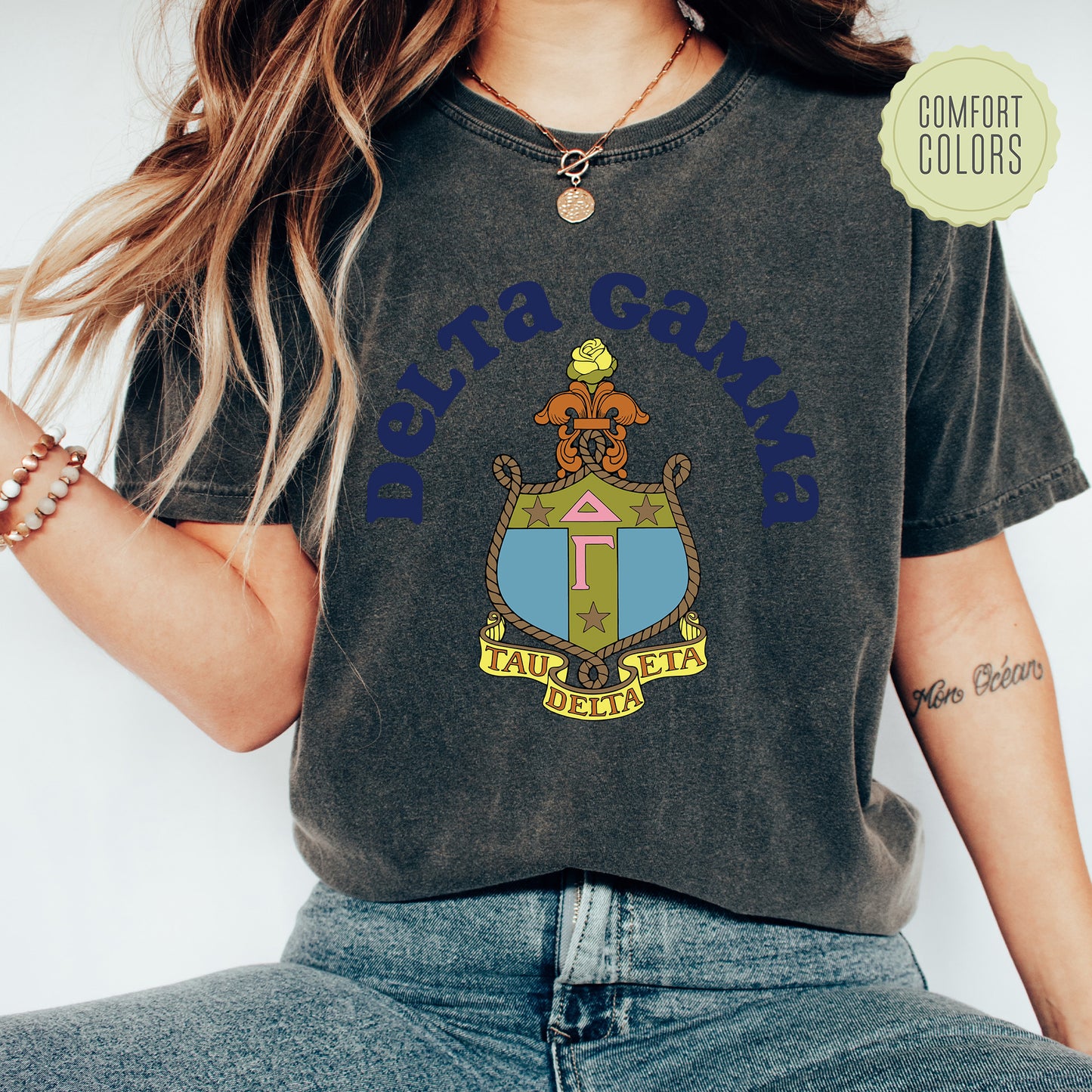 a woman wearing a shirt with a coat of arms on it