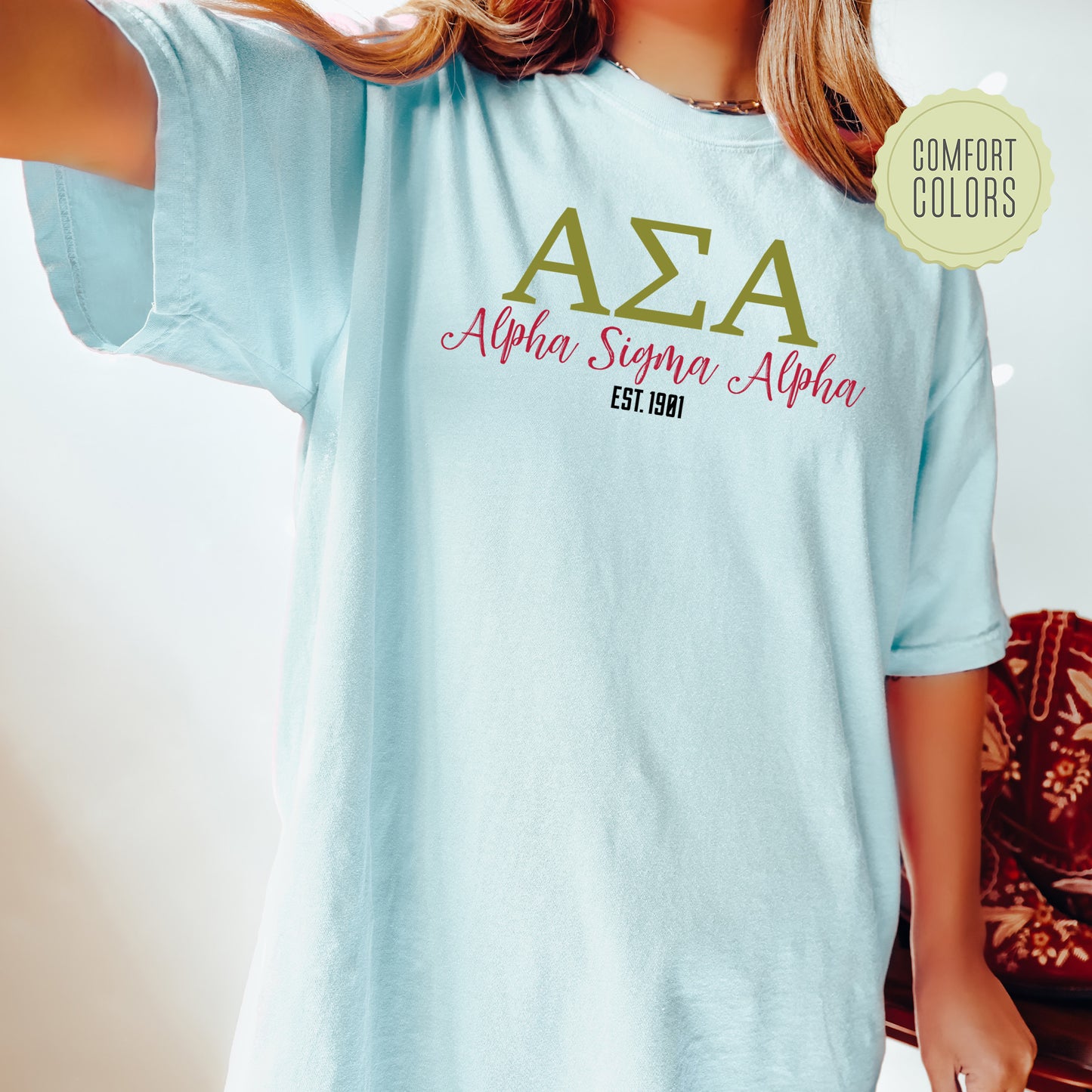 a woman wearing a light blue t - shirt with the word aza on it
