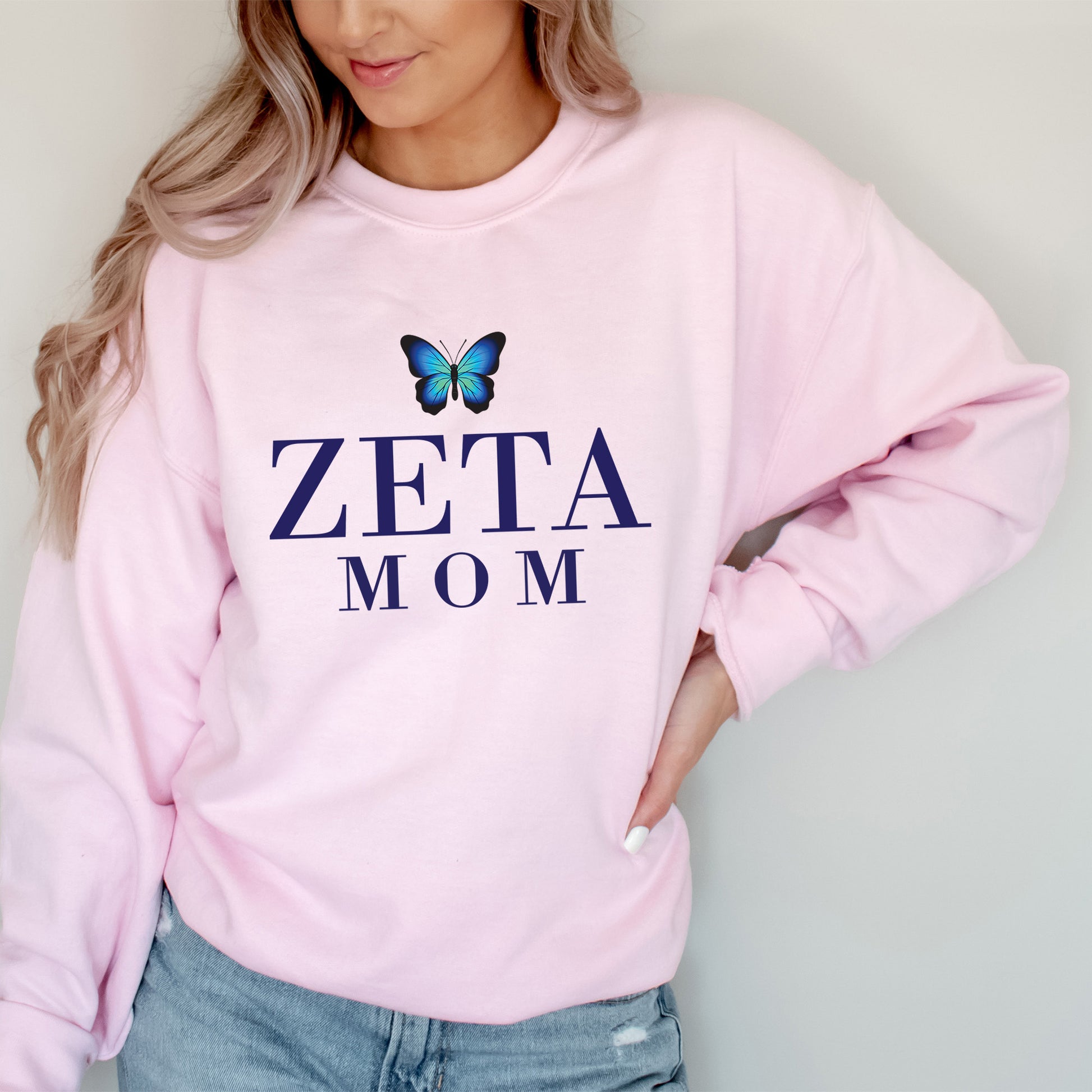 a woman wearing a pink sweatshirt with a blue butterfly on it