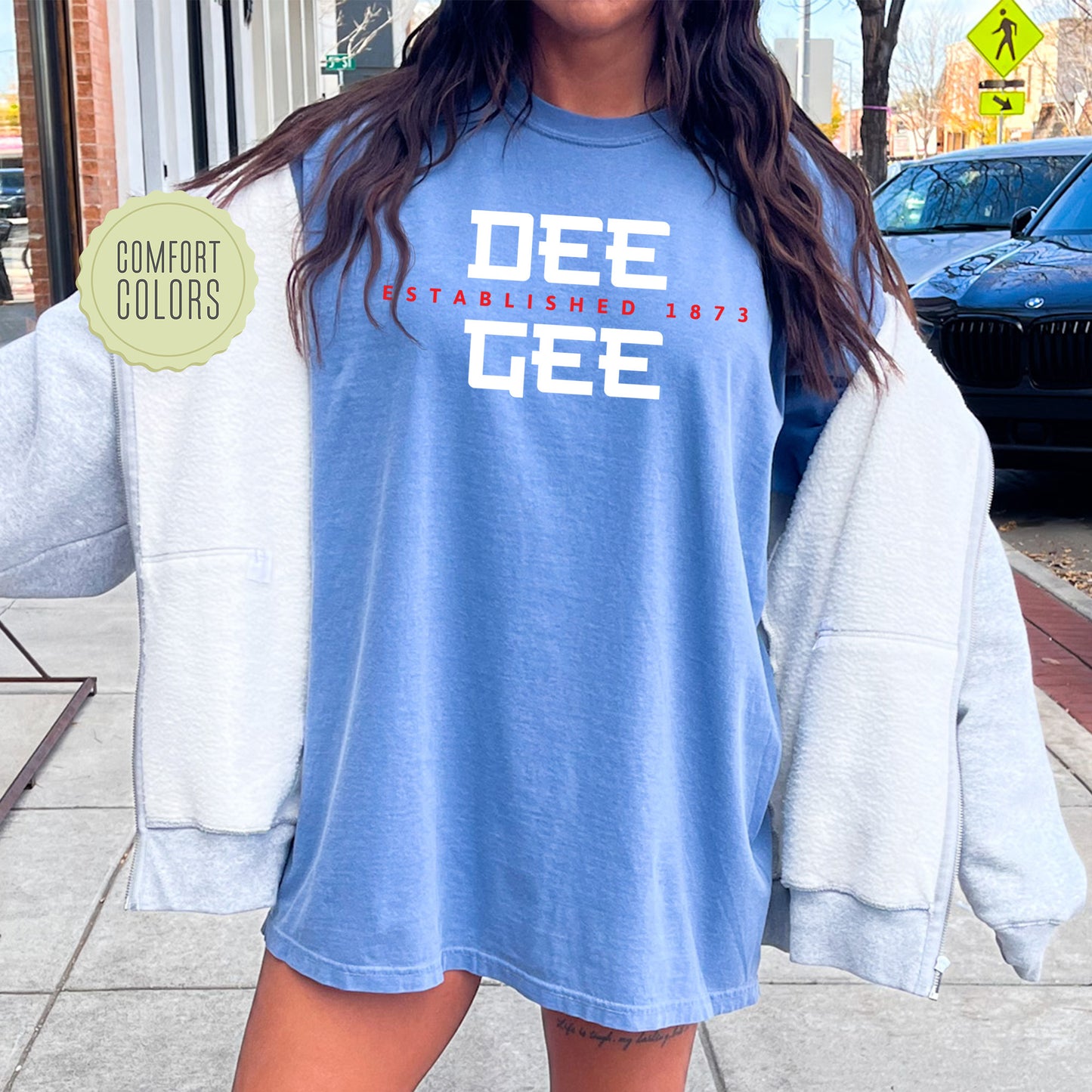 a woman standing on a sidewalk with a blue shirt