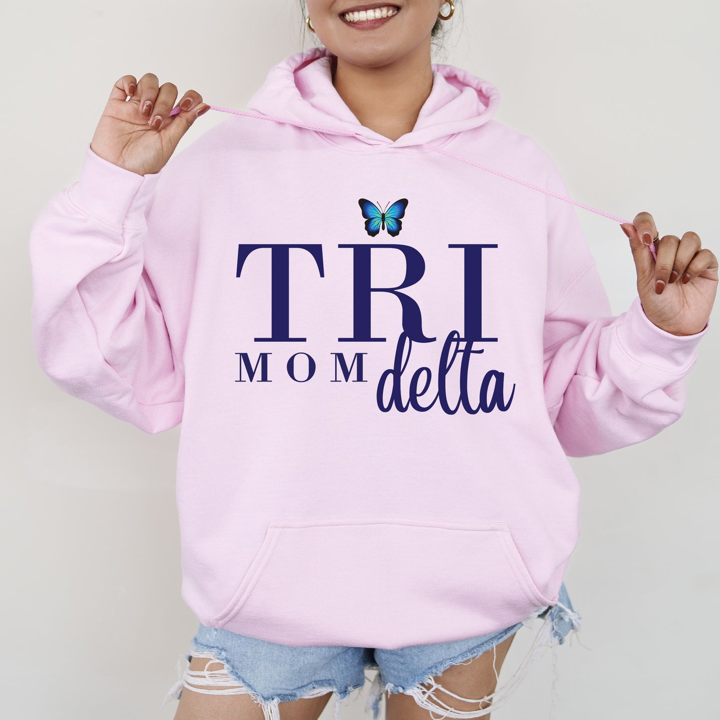 a woman wearing a pink hoodie with a butterfly on it