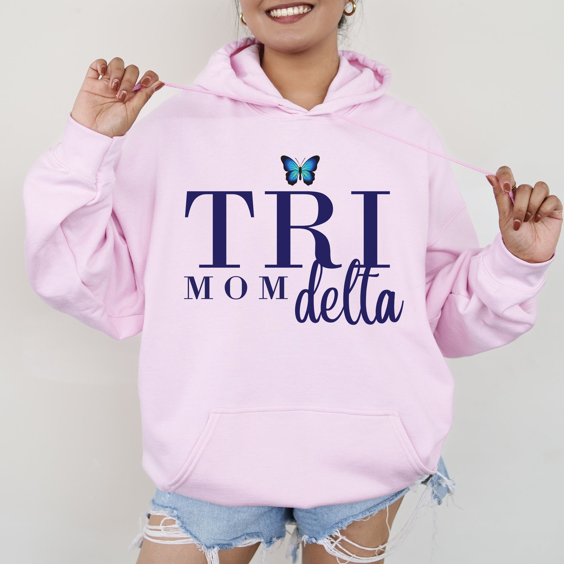 a woman wearing a pink hoodie with a butterfly on it