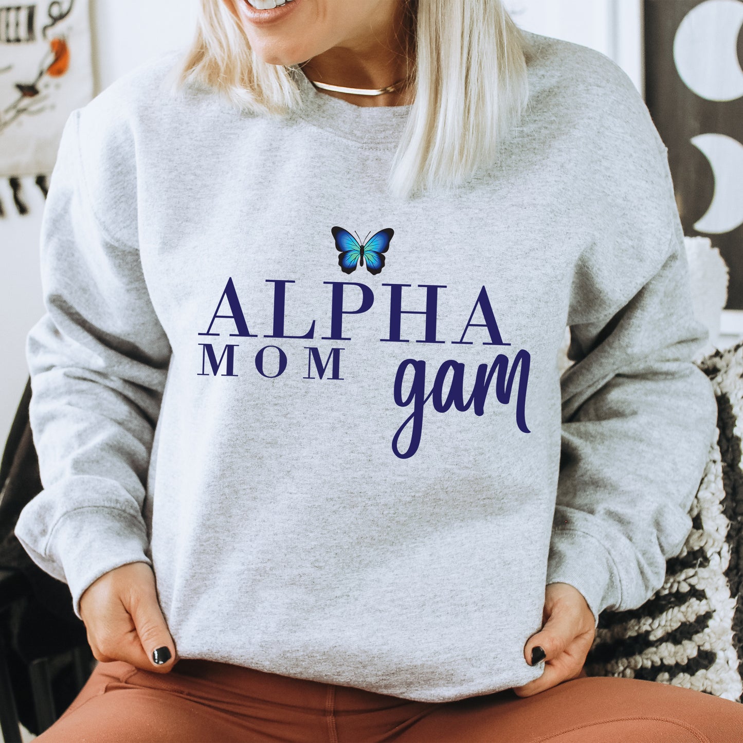 a woman sitting on a chair with a butterfly on her sweatshirt