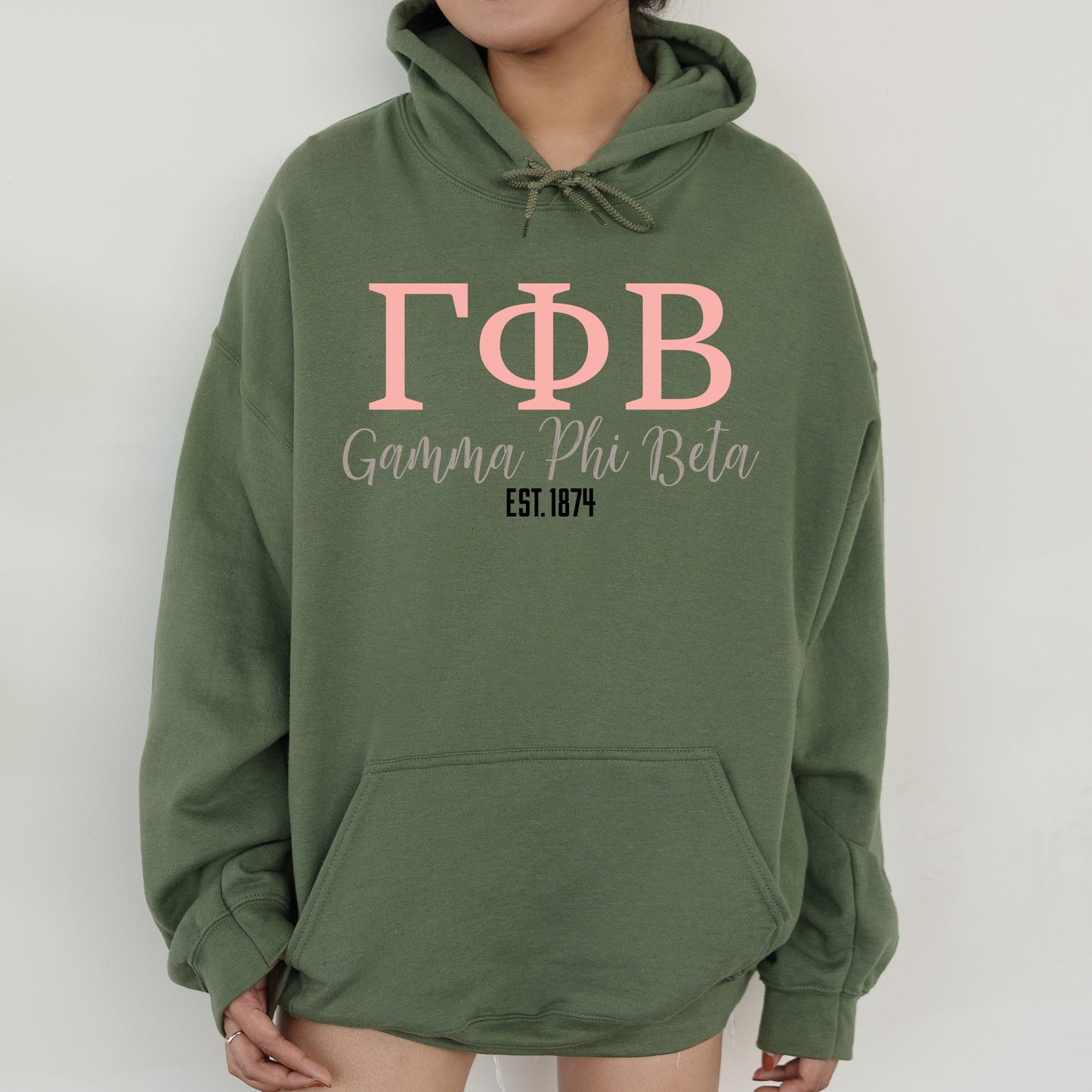 a woman wearing a green hoodie with pink letters