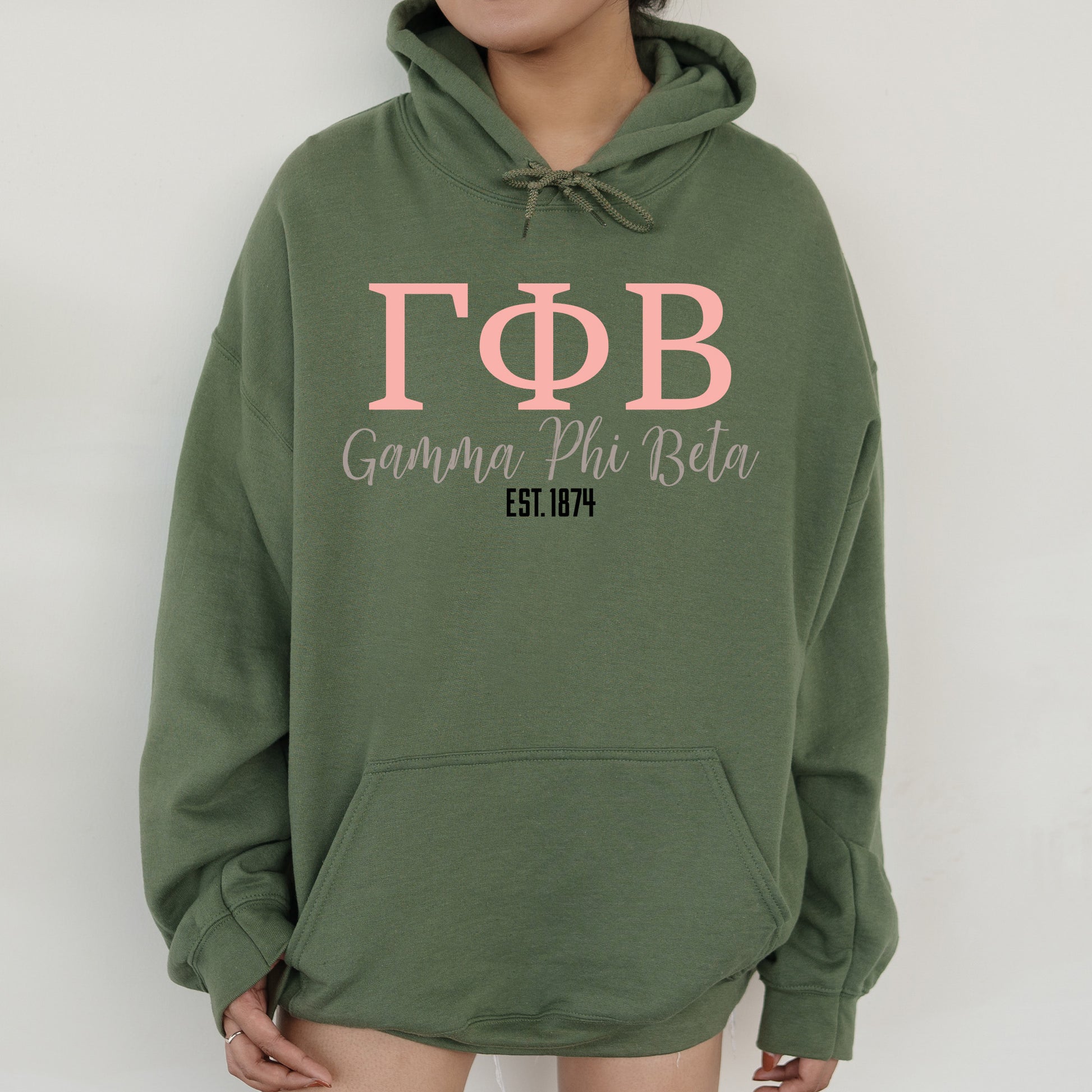 a woman wearing a green hoodie with pink letters
