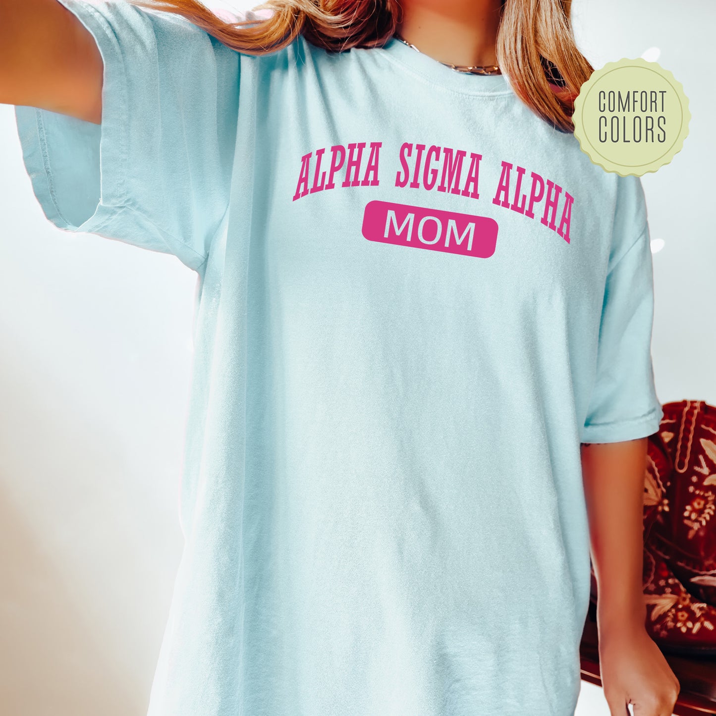 a woman wearing a light blue shirt with pink letters on it