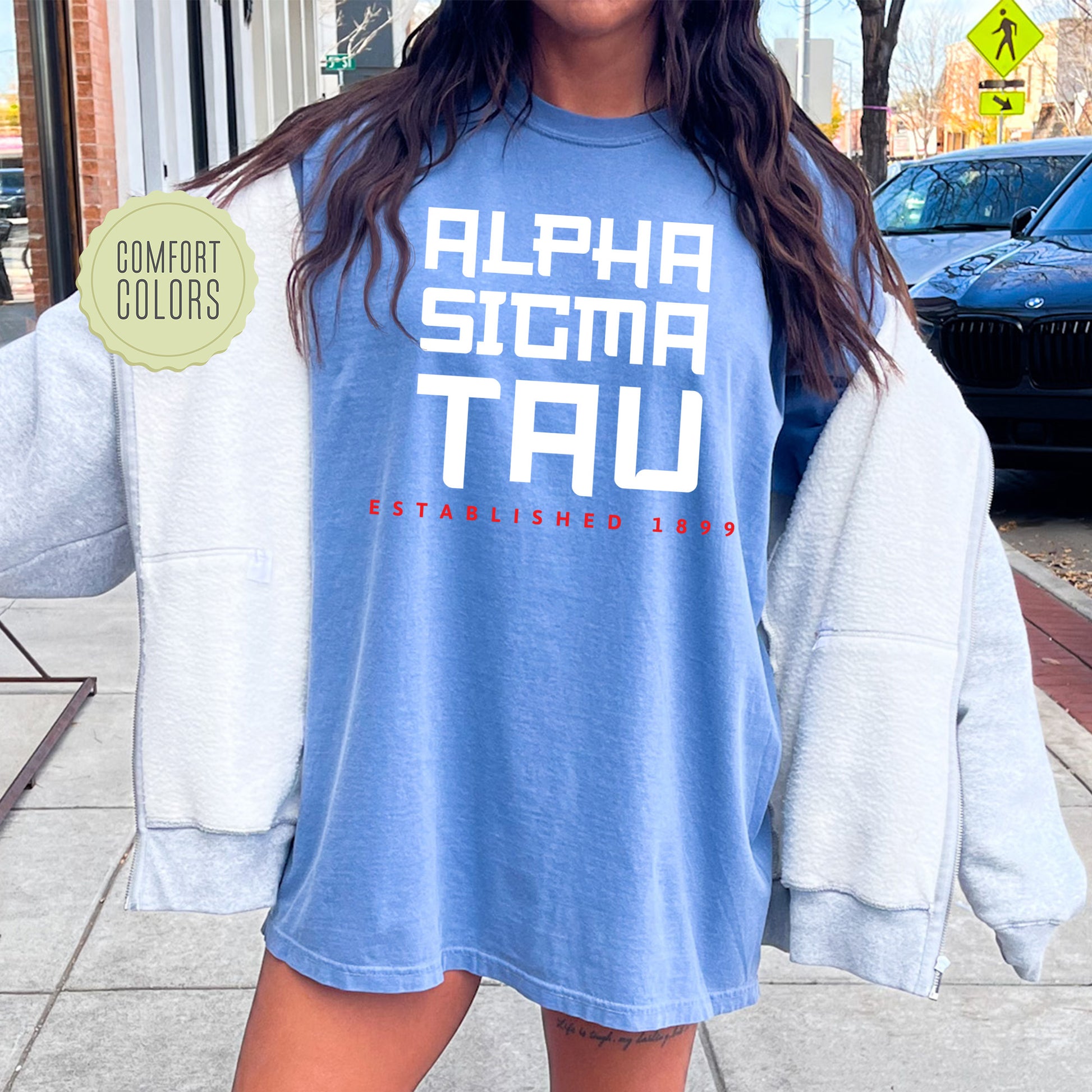 a woman is standing on the sidewalk wearing a blue shirt
