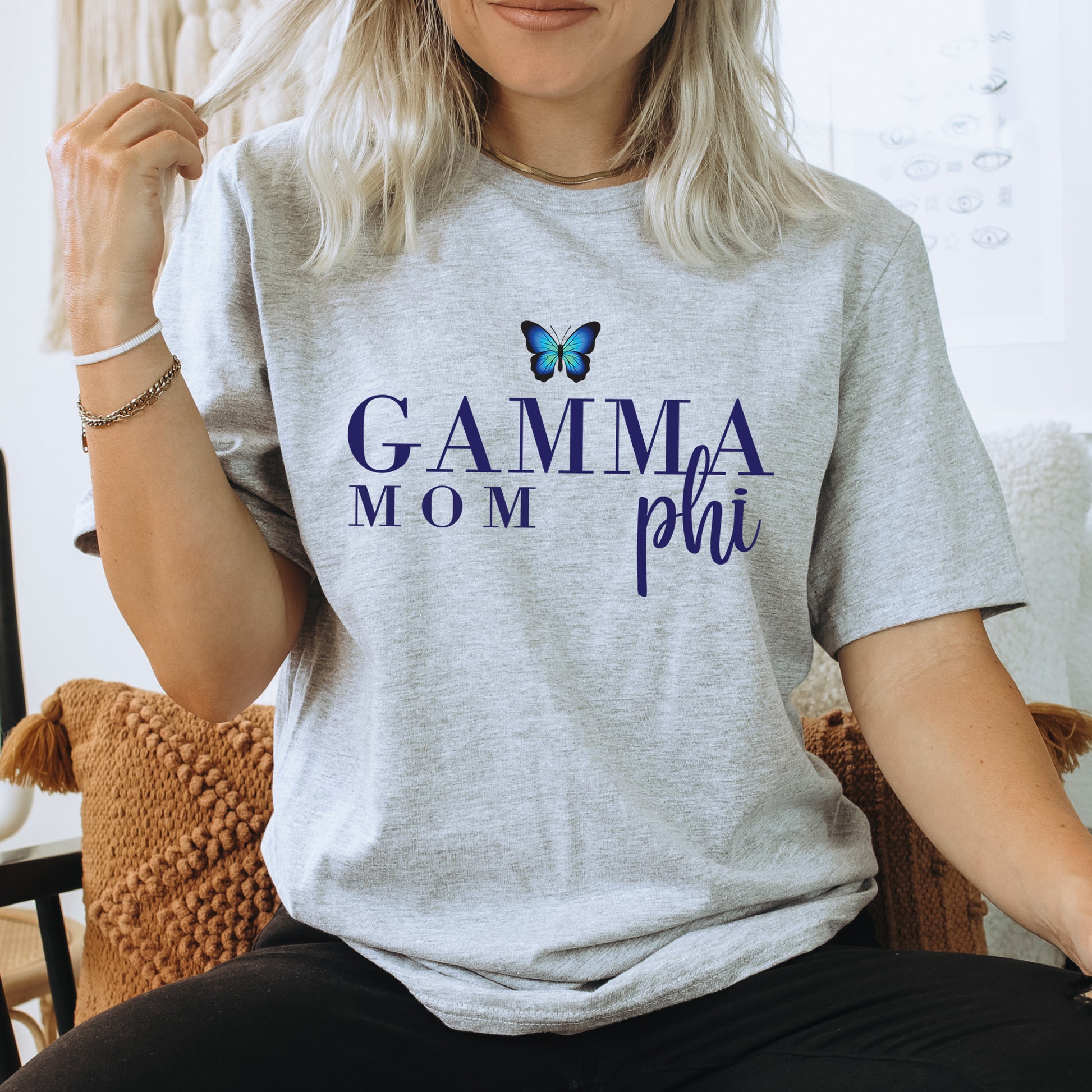 a woman sitting on a chair with a butterfly on her shirt